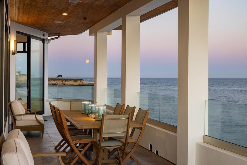 Experience unparalleled coastal living in this one-of-a-kind contemporary oceanfront home, set on over 500 feet of beachfront with stunning 240 degree views through expansive floor-to-ceiling windows. Fully remodeled, this luxury retreat is among Santa Cruz's most exceptional properties. Located on a ~3/4 acre private point, it offers dramatic views of the beach and lighthouse from nearly every room. The open layout includes a chef's kitchen, an atrium-style game room that opens to an outdoor BBQ area, and a relaxing ocean-view hot tub. Each bedroom features its own en-suite bath and breathtaking surf views. A separate lower-level suite with private entry, kitchen, living room, bedroom, and bath offers flexible living or guest quarters. Enjoy your own sandy beach area, with a gated path providing direct access to the public beach. Just a short beach stroll to the harbor, this rare gem blends privacy, luxury, and location into the ultimate Santa Cruz lifestyle.