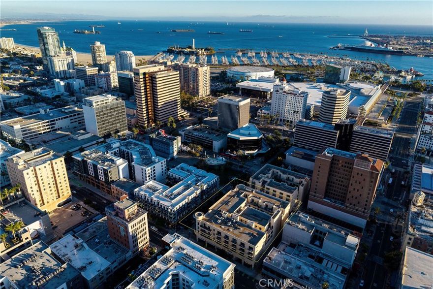 Discover the ultimate expression of coastal luxury and vibrant downtown living, where modern design meets the heartbeat of the city. This ultra modern space is far more than a home, it is a lifestyle destination. With an impressive 1,050 sq ft of bold open concept living, this is the largest one bedroom layout in the building and a rare opportunity to live expansively in one of Long Beach’s most desirable urban communities. Vaulted ceilings enhance the airy atmosphere while natural light illuminates every corner. The massive living and dining area with a nook offers flexibility to design the perfect entertainment space, home office, or relaxation zone. Rich hardwood and designer tile flooring add warmth and style, while the quartz gourmet kitchen features stainless steel appliances including a brand new dishwasher. Additional conveniences include AC,  in-unit laundry, a modern tankless water heater, and a large hallway storage closet. The spacious bedroom offers excellent storage with double closets. Enjoy Promenade facing views from your private balcony, where you can start your morning with sunshine and unwind in the evening as city lights shimmer. Two gated underground parking spaces plus a significant deeded storage cage provide convenience rarely found in urban living. Located in the exclusive beautifully maintained building, the amenities include guest parking, EV charging, a bike room, a stylish club lounge with a kitchen, television, pool table and shuffleboard, a gym with a yoga studio, and an outdoor courtyard with lounge seating and a cozy firepit. High speed internet, water, trash, and sewage are included in the HOA, providing comfort and ease for homeowners. The location is unbeatable, with the beach, boardwalk, marina, Pike Outlets, Shoreline Village, restaurants, cafes, shopping, nightlife, parks, entertainment, and the Metro line all just moments from your front door. Annual Grand Prix excitement and ongoing waterfront development keep this community vibrant and energetic. Looking toward the future, the 2028 Olympics will bring global attention and major international events to Long Beach including beach volleyball, coastal rowing, sailing, target shooting, sport climbing, handball, canoe sprint, and rowing. Live at the center of world class culture, sports, and coastal excitement. Luxury, location, and lifestyle come together where the ocean meets the city and your future feels inspired.