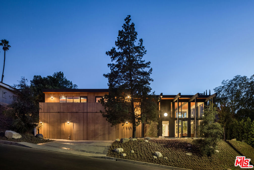 This period perfect FRYMAN CANYON 5 bed, 5 bath, Mid-Century Post & Beam renovation embodies the ethos of its time by staying true to its clean lines and careful simplicity with thoughtful re-imagining to cater to today's modern living and entertaining. This three year renovation was designed and carefully sourced by a high-end design group with absolutely no expense spared, using skilled craftsmen and custom wood artisans for one-of-a kind creations. This Dwell featured home has floor to ceiling walls of glass in an awe-inspiring living room with 20 ft ceilings, complemented by a massive matte black fireplace and stunning slate floors that seamlessly extend to the outdoor space, fusing the indoor and outdoor space with ease and complete privacy. Experience a deep connection to nature through multiple walls of glass, opening to wonderful outdoor spaces showcasing earth, fire and water elements, with a new pebble-tec salt water pool/spa, gas fire pit sitting area, wood deck and picturesque landscaping, including Japanese Maple trees and blooming Magnolias. An expansive gourmet kitchen has a 25 foot Quartzite island, with Miele appliances, and an island of slatted white-oak mill work cabinetry designed and made for the space by artisans. Slatted wood design accents grace the stunning staircase to the upstairs loft and bedrooms. White Oak wide plank floors span the upstairs space, where all upstairs bedrooms are en-suite with bathrooms featured in House Beautiful and various other publications. The large primary suite has a balcony and mountain views, with a room sized closet with 8 custom-built Oak wardrobe closets with additional built-in drawers offering plentiful enclosed wardrobe and shoe storage. The primary bathroom has a custom made dual vanity, Quartzite counters, terrazzo floors and a large walk-in shower and separate soaking tub. Automatic blinds in most rooms allow light or privacy instantly. Two laundry rooms, one on each level. There are simply not enough words to describe this breathtaking and emotional home. Furnishings are a fusion of restored Danish/European MCM imports and new Modern. If your clients are looking for an ultra-sexy renovated lease that is NOT your cookie-cutter new construction, THIS IS IT. Just a couple blocks to serene hiking trails and close to all the studios, with easy access to Beverly Hills and Hollywood and top rated Carpenter School District. This visually captivating home is unrivaled in today's rental market!