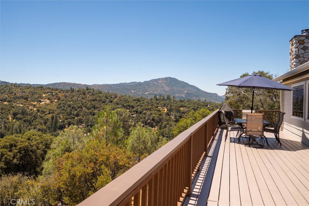 Perched atop a scenic hilltop, this beautifully maintained home offers breathtaking views from every room and from the expansive brand-new approximately 1000 square foot wraparound deckthe perfect place to relax, entertain, or soak in the stunning surroundings. A long, paved driveway leads you to this light-filled retreat featuring owned solar with 24 panels, Anderson doors and windows, brass faucets, skylights throughout, and a smart, functional layout. The primary suite is conveniently located on the main level, while the lower level offers two additional bedrooms, a full bath, and a cozy shared living space that opens to the backyardideal for guests or multi-generational living.You'll love the well-equipped laundry room with a sink, ample counter space, built-in ironing board, and generous storage. Every inch of this property has been thoughtfully maintained and designed for comfort, ease, and energy efficiency. There is also a 3-car attached garage including work bench and storage cabinets, as well as a large detached shed for additional tools and equipment storage.All of this just minutes to the shops and restaurants of Oakhurst, Bass Lake's recreational paradise, and only 30 minutes to Yosemite's south gatea perfect primary residence, vacation home, or income opportunity in the heart of the Sierra.