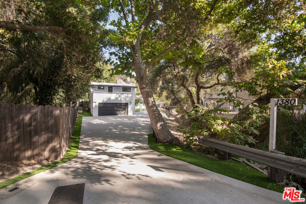 A rare property in Old Topanga with a second entrance from the quiet Bonnell Drive. This beautifully remodeled view filled three-bedroom home offers modern amenities, unexpected upgrades, and one of the largest flat lots in the area. You'll appreciate the expansive, usable yard rarely found in Topanga.The home features a stylish kitchen with classic white shaker cabinets, sleek quartz countertops and stainless appliances. You'll love cooking and entertaining in this beautiful space, which opens up to a lovely outdoor patio where you can soak in the peaceful ambiance of your surroundings. Kitchen accesses a full laundry room with storage, utility sink and a side entrance to outdoors. The main level includes one bedroom and full bath, while two additional bedrooms and a full bath are located upstairs, with access to the second story deck. The spacious living room has vaulted ceilings, recessed lighting, and a striking fireplace, creating a bright and inviting atmosphere for entertaining or relaxing. Upgraded privacy-maintaining windows fill the space with natural light while ensuring a peaceful indoor retreat and blocking the UV rays. The real magic of this property lies outside, where you'll find a sprawling, beautifully landscaped yard with plenty of space for outdoor activities and entertaining, while being completely fenced. In the rear of the yard is a detached studio guesthouse, complete with a 3/4 bath and patio. Outdoors offers one of the largest, flattest yards in Topanga Canyon, with a large patio area, easy care turf. A wooden bridge crosses over the seasonal creek leading to another sunny yard perfect for those wanting to have a veggie garden, complete with a container ideal as a workshop, garden shed, or additional storage. with water and electric outlets The second entrance on Bonnell Drive has an automatic gate and room to park an RV or extra cars. Additional highlights include a two-car garage equipped with an EV charger, Ring doorbells at the front entrance and garage.A rare find in Topanga, this property combines flat usable land, upgraded finishes, and quiet privacy It's a short distance to Bonnell Park, Red Rock Park and the Skyline Loop. Improvements completed in 2023 and 2024 include roof, windows, HVAC, kitchen and bath remodel, flooring, paint, plumbing, electric, detached guest house/office and automatic gate on Bonnell. Both full baths have also been remodeled in the same style as the kitchen. All flooring has been redone, with warm toned high-quality engineered wood and carpets.
