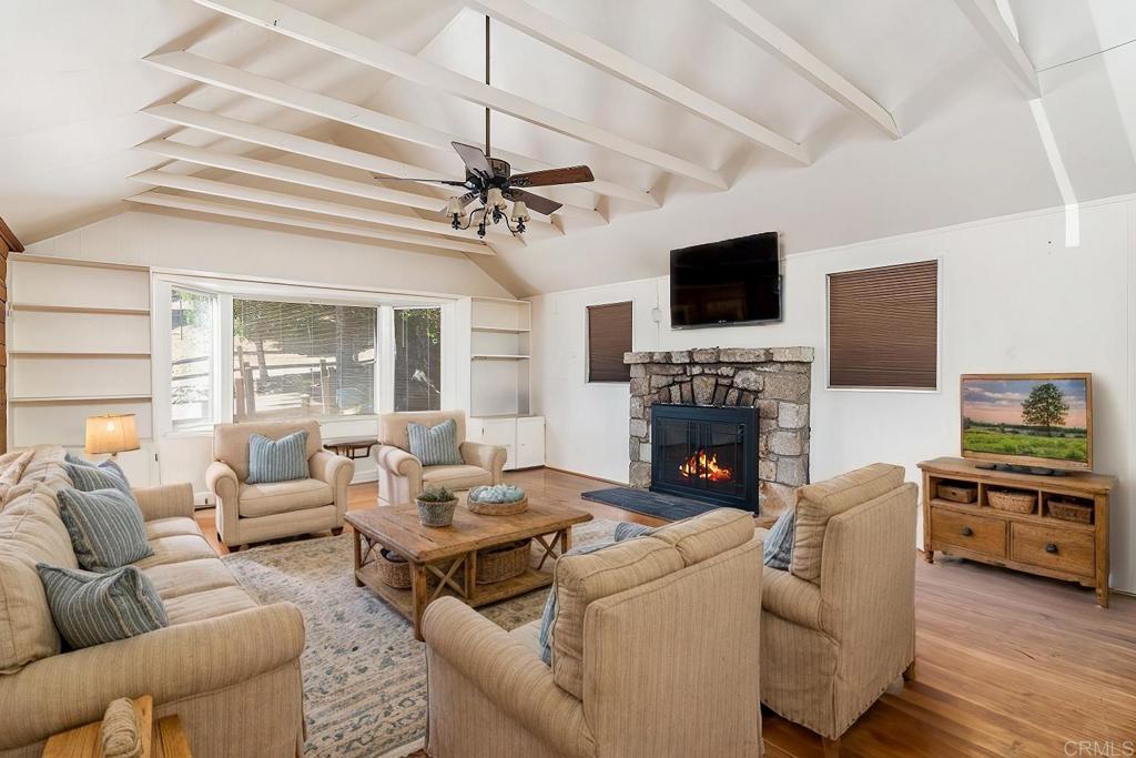 Welcome to your charming mountain escape in the heart of Rimforest! Situated on a spacious lot along a peaceful street, this delightful cabin blends historic character with thoughtful modern touches—just minutes from the beauty and recreation of Lake Arrowhead. Originally built in 1932, the home showcases timeless architectural details, including an eye-catching original stone fireplace that anchors the expansive living room. High ceilings and a cozy bay window create a bright, airy ambiance—perfect for relaxing after a day in the mountains. Step inside to a sunlit entry room, where large windows flood the space with natural light and offer serene views of the surrounding greenery. The kitchen is warm and inviting, featuring classic wood cabinetry and all the essentials for preparing meals or entertaining guests. This home offers two comfortable bedrooms, a functional office nook, and one full bathroom, making it an ideal year-round residence, weekend retreat, or vacation rental. Whether you’re curling up with a book by the fire or working remotely in the quiet office space, you’ll feel right at home. Outside, the generous lot provides ample parking, room to roam, and plenty of outdoor space for gardening, lounging, or even expansion. Two storage sheds offer convenient solutions for tools, equipment, or outdoor gear—perfect for anyone who loves to explore and stay organized. With its vintage charm, great layout, and prime location, this property is brimming with potential and ready for your personal touch. Whether you're looking to create a cozy mountain getaway, an artist’s retreat, or a peaceful primary residence, this is your chance to make it truly yours. Don't miss this unique opportunity to own a piece of Rimforest history in a setting that offers both tranquility and convenience. Come see this inviting cabin today and imagine the possibilities!
