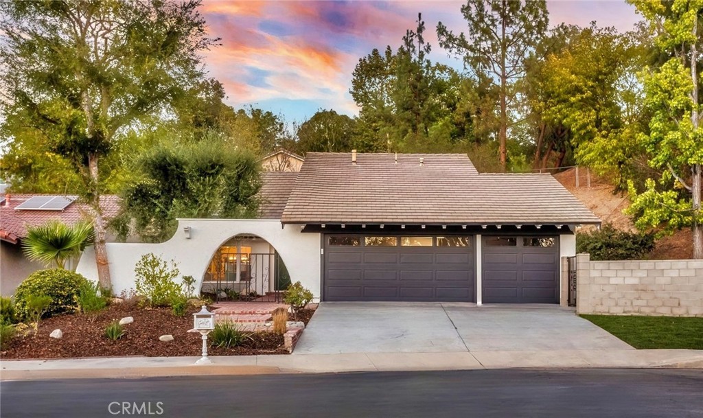 Welcome to this stunningly reimagined POOL home, ideally situated at the end of a serene cul-de-sac in the highly coveted Fountainwood tract of Agoura Hills. Perfectly placed on one of the largest lots in the neighborhood, an expansive 23,000 sq. ft. this property offers unparalleled privacy, luxury living with a modern esthetic. Pass through the gated courtyard and elegant double-door entry to discover nearly 2,700 sq. ft. of renovated living space. Inside, you will find soaring cathedral ceilings, a dramatic spiral staircase, and tons of windows that fill the space with natural light. Experience wide plank flooring in a white oak finish, designer lighting, fresh modern paint selections, and custom built-ins throughout the home. The chef’s kitchen is a dream, featuring custom cabinetry in agreeable beige with integrated spice racks and appliance storage, Calacatta Amani quartz counters with seamless backsplash, a custom hood accented with white oak detailing, floating shelves, walk-in pantry, microwave drawer, and a statement white oak island with seating for four perfect for both casual dining and entertaining. The lower level primary suite enjoys its own private wing, ideal for guests or multi-generational living, and includes backyard views, generous closet space, and a luxurious spa like bath. The powder bath is finished with a custom white oak floating vanity, hex tile, and a contemporary vessel sink. Upstairs, the second primary suite offers a private balcony, expansive walk-in closet, and a breathtaking ensuite bath with floor to ceiling tile, quartz double custom vanity, and a stunning walk in shower with an extra long bench. Secondary bedrooms are spacious with ample storage, while the hall bath boasts dual sinks, a large soaking tub, and separate shower. Modern upgrades include fully paid solar, new HVAC system, recessed lighting, indoor laundry room, new irrigation system, and a three-car garage. Step outside to your own private resort with a brand new pool and elevated spa, multiple lounging areas, a huge side yard for play, and plenty of space to entertain. Located moments from award winning schools, shopping, dining, and freeway access, this residence combines luxury, comfort, and a prime Agoura Hills setting, perfect for the buyer seeking an elevated lifestyle.