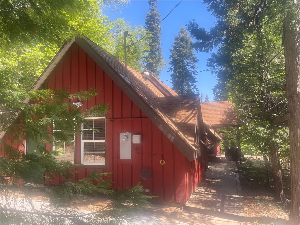 Charming 3-bedroom, 1 ¾ baths mountain cabin is walking distance to the Lake (with Lake Rights/access trail point #11) in the coveted “Alphabet Streets” just beyond the end of a Cul de sac off John Muir Rd. Enjoy an expansive front deck framing the full length of the home located about one mile from the Arrowhead Village entrance. The cabin’s open floor plan includes a large living room with soaring cathedral ceilings and stone fireplace, dining area flanked by a bank of floor-to-ceiling windows/sliders and large kitchen with bar/island. A large ensuite primary with seating area and other bedrooms are each on opposite sides of the main living area (two bedrooms each have a separate exterior entrance). Other features include bonus room/murphy bed w/pocket door separation, heated floors in bath and hallway, skylights, new plumbing/electrical & TREEHOUSE. A long driveway can accommodate 3 cars.
Adjacent gentle sloping vacant lot directly behind house on C Lane (available for purchase). Vacant lot parcel #0331-221-31-0000 (.17 acre). Additional storage on property with detached Tuff shed.