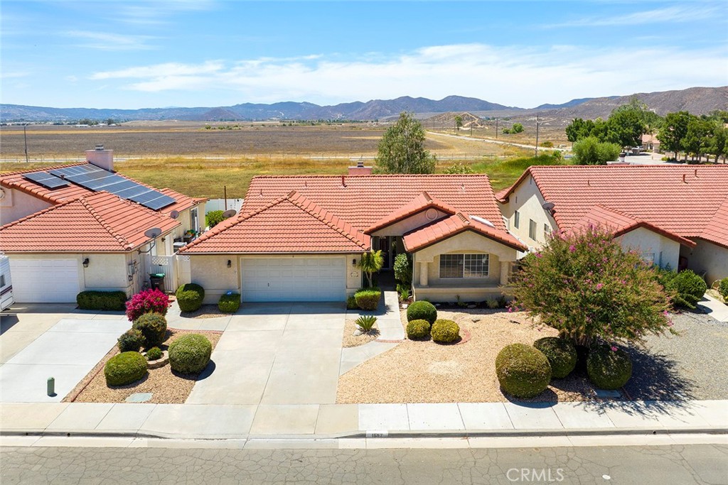 Charming Hemet Home with Dual Main suite bedrooms and Stunning Views
Welcome to your dream home! This beautifully maintained residence offers a spacious layout featuring two main suites with private bathrooms, plus an additional office/guest bedroom with built-ins, and an attached 2-car garage.
The inviting living room boasts plush carpeting, vaulted ceilings, a cozy gas fireplace, recessed lighting, and abundant natural light. The living room flows seamlessly into a generous dining area with parquet flooring, chandalier and sets adjacent to the kitchen and an enclosed bonus room.
The kitchen is equipped with classic wooden cabinetry, gas range, white appliances, a morning sun garden window, a peninsula island. Just off the kitchen, you’ll find a large laundry room with gas and electric dryer hookups, a utility sink, additional storage cabinets, and direct access to the spacious garage.
At the rear of the home, a large enclosed bonus area overlooks a fully fenced watershed basin that attracts ducks and other wildlife during the rainy season. The backyard is a lush, green oasis, complete with finished landscaping, shade trees, and irrigation.
Enjoy the primary master suite, which features generous wall of closets, a private bath with a large separate shower, a soaking tub, and a dual-sink vanity. The second suite includes a full bathroom with a shower/tub combo, a spacious closet, and a skylight.
Step outside to enjoy the serene patio area and beautifully maintained garden—perfect for relaxing or entertaining. From the backyard, take in the open views of the surrounding landscape, offering peace and privacy with white vinyl fencing and shady area for picnics.
The front yard is done with water and timesaving landscaping but still has beautiful curb appeal.
This property is ideally located near local amenities, making it the perfect blend of comfort and convenience.