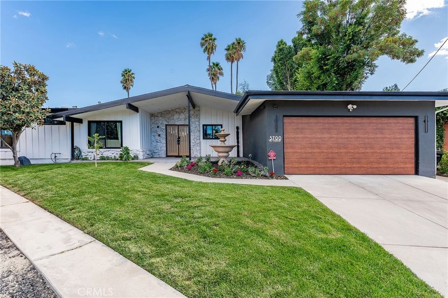 Gorgeous single story Mid-Century modern Charles Du Bois with newly built swimming pool and dazzling Valley, mountain, & city light Views! The property is situated at the very end of a quiet cul-de-sac West of Valley Circle on an expansive private lot. The home sits back from the street with large grass lawn & covered front porch adorned with natural stone & wood siding. Step through double doors into the entry foyer with custom wood accent wall, coat closet, & wide plank oak wood flooring found throughout. The entry opens directly to the oversized living & dining rooms each featuring vaulted wood beamed ceilings, double sided stone fireplaces, wood accent walls, & large glass sliders that open to the backyard for the perfect indoor/outdoor flow. The dining room additionally has a built-in bar with wine fridge & storage. The stunning chef’s kitchen opens to all living spaces and boasts center island with Brazilian quartzite countertop, custom soft close white oak cabinetry, dimensional tiled backsplash, stainless appliances including a 48” range with double ovens & 6-burner stove + griddle, Fisher & Paykel fridge/freezer, and separate breakfast nook with glass slider that opens to a side patio perfect for sipping your morning coffee. The luxurious primary bedroom features high vaulted ceiling, venetian plaster accent wall, large glass slider that opens directly to the pool, spacious walk-in closet with built-ins, & en-suite spa bathroom with floating vanity, dual sinks, walk-in shower, soaking tub, & smart bidet toilet. Two secondary bedrooms are each well appointed with custom closets. Each room has access to a private bathroom with walk-in shower, something seldom seen with Du Bois layouts. One of the bathrooms is located at the end of the hallway with exterior access great to use for both a guest powder bath & pool bath. The backyard is truly an entertainer’s retreat highlighted by a 2023 newly built heated pool with Baja lounging deck & cascading fountains, sprawling grass lawn, BBQ center with fridge & bar top seating, plus sweeping patio perfect for outdoor dining. Additional features include finished 2-car garage with direct access & epoxy flooring, smart home technology including built-in audio, smart lighting, & security system with cameras. Adjacent to dining/shopping at the Westfield Mall/Village, Calabasas Commons, local parks/hiking trails, & zoned for award-winning El Camino & Hale charter schools.