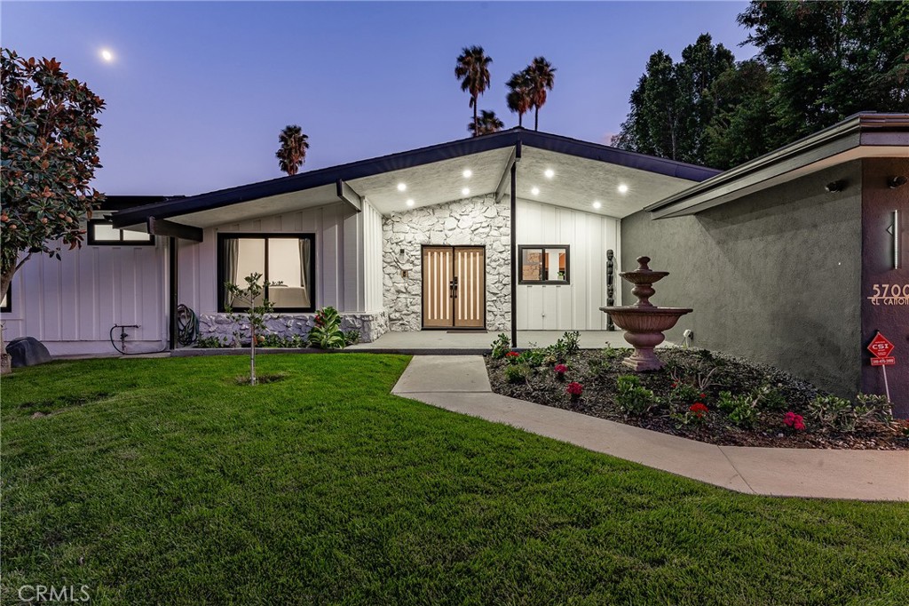 Gorgeous single story Mid-Century modern Charles Du Bois with newly built swimming pool and dazzling Valley, mountain, & city light Views! The property is situated at the very end of a quiet cul-de-sac West of Valley Circle on an expansive private lot. The home sits back from the street with large grass lawn & covered front porch adorned with natural stone & wood siding. Step through double doors into the entry foyer with custom wood accent wall, coat closet, & wide plank oak wood flooring found throughout. The entry opens directly to the oversized living & dining rooms each featuring vaulted wood beamed ceilings, double sided stone fireplaces, wood accent walls, & large glass sliders that open to the backyard for the perfect indoor/outdoor flow. The dining room additionally has a built-in bar with wine fridge & storage. The stunning chef’s kitchen opens to all living spaces and boasts center island with Brazilian quartzite countertop, custom soft close white oak cabinetry, dimensional tiled backsplash, stainless appliances including a 48” range with double ovens & 6-burner stove + griddle, Fisher & Paykel fridge/freezer, and separate breakfast nook with glass slider that opens to a side patio perfect for sipping your morning coffee. The luxurious primary bedroom features high vaulted ceiling, venetian plaster accent wall, large glass slider that opens directly to the pool, spacious walk-in closet with built-ins, & en-suite spa bathroom with floating vanity, dual sinks, walk-in shower, soaking tub, & smart bidet toilet. Two secondary bedrooms are each well appointed with custom closets. Each room has access to a private bathroom with walk-in shower, something seldom seen with Du Bois layouts. One of the bathrooms is located at the end of the hallway with exterior access great to use for both a guest powder bath & pool bath. The backyard is truly an entertainer’s retreat highlighted by a 2023 newly built heated pool with Baja lounging deck & cascading fountains, sprawling grass lawn, BBQ center with fridge & bar top seating, plus sweeping patio perfect for outdoor dining. Additional features include finished 2-car garage with direct access & epoxy flooring, smart home technology including built-in audio, smart lighting, & security system with cameras. Adjacent to dining/shopping at the Westfield Mall/Village, Calabasas Commons, local parks/hiking trails, & zoned for award-winning El Camino & Hale charter schools.