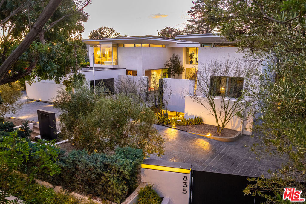 Art meets architecture in the heart of Santa Monica in this exquisite embodiment of California luxury living. Completed in 2022, this unparalleled sanctuary of tranquility and seclusion is a design masterpiece that genuinely elevates the bar for exclusivity and sophistication. Secure behind custom gates and fortress-esque walls lie masterfully designed grounds and a home that artfully blurs the distinction between indoor and outdoor space. At its heart, a breathtaking retractable ceiling creates a sky-framed tableau above an elegant sitting room, and the 21-foot automated Fleetwood doors open onto an idyllic outdoor haven, complete with a zero-edge pool, spa, and zen koi pond. The residence boasts dual elevators, seven en-suite bedrooms, and twelve bathrooms (each a study in comfort and style) and showcases lofty ceilings and a thoughtful layout throughout. The main level features a formal sitting room, comfortable family room, state-of-the-art kitchen with Gaggenau appliances, and an additional industrial-grade chef's kitchen. Upstairs, the primary suite offers stunning garden and mountain views, boutique-style closets, and an opulent heated floor bathroom, while the opposite upper wing features three additional en-suite bedrooms suitable for discerning guests. A voice-activated Josh AI smart home system, spa center with wet/dry sauna and Himalayan salt wall, state-of-the-art gym, wine cellar, media room, and two showcase garages for the automotive connoisseur leave nothing to be desired. This harmonious fusion of grace, style, and functionality deserves its status as one of the most well-designed and exclusive properties ever conceived in Santa Monica.