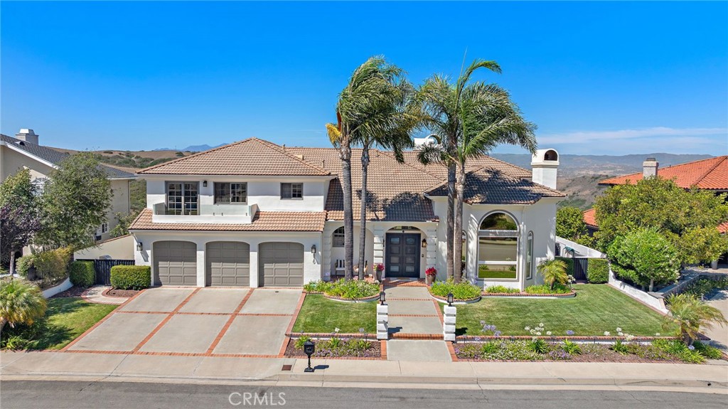 Elevated high in the hills of Southeast San Clemente on one of the area’s most desirable streets, this well-appointed home is a true showcase of pride of ownership. Driving to the summit alone inspires a sense of luxury living. Positioned along a wide (hardly-traveled) street among several large-scale, extremely custom estates, this home and surroundings are sure to impress. Upon arrival, curb appeal has been re-invented with a fresh coat of paint, refreshed landscaping, new entry doors & glass railings-an undeniable stand out. Inside large, steel, double doors, a formal entry draws you into grand two-story spaces. A well-appointed living room invites you in with arched features, coffered ceiling, major natural light, gorgeous wood floors, & detailed fireplace. Views of rolling hills across the formal dining room resemble a plein air painting. Parquet wood flooring details the floor. A spacious family room with wet bar, fireplace, & large view deck create the perfect place to unwind. Just off the family & dining rooms, beautiful wood floors lead to a massive entertainer’s kitchen with room for everyone to congregate. Offering ample cabinetry, stone flooring & counters, large centered island, stainless appliances, walk-in pantry, informal dining, all with surreal views of the etched hills abound (preserved land), this kitchen is just right. Up the grand staircase, wide hallways lead to three primary-like suites. The true primary is huge with major views. Coffered ceilings, fireplace, wired sound, exterior view deck, dual closets, spa-like bathroom with soaking tub, privacy toilet, dual sinks, beautiful wood cabinetry, & variable shower heads all make it exceptional. Two additional (giant) suites complete the upper level, one with view deck off the front (new glass railings). On the lower level (potential guest quarters), a fourth suite, a fifth bedroom (currently an office), & a large bonus room outfitted as home theatre with seating, projector, screen, & AV equipment. Slider doors access the rear patio & slope beyond. Major development potential: large decking, putting green, terraces, citrus grove planters, etc. Other values: zoned HVAC, fire sprinklers, massive 3-car (dialed-in) garage, peek ocean views, no HOA, on over an acre, homes of this caliber are truly rare to come by. Accessible to nearby trail systems including ridgeline & 2.5 mile beach trail, new restaurants, SC Pier, bikable to nearby world-class surfing at trestles, & amazing beaches.