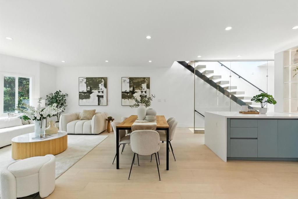 Experience this modern luxury design, meticulously renovated home in Inner Sunset. Step inside to a sun-drenched interior featuring white oak hardwood floors, expansive skylights, and architectural floating staircases with full glass railings, adding a sleek, open feel throughout the home.The gourmet kitchen, outfitted with a stylish island, sleek cooktop, built-in microwave, and seamless flow into the living and dining areas. A true highlight is the rooftop deck, accessible via a rain-sensor skylight system that blurs the line between indoors and out. Take in breathtaking panoramic ocean views ideal for relaxing,entertaining, or enjoying San Franciscos stunning sunsets.The primary suite offers a private retreat with a balcony, spa-like bathroom, and generous closet space. Enjoy whole house radiant heating, with individual thermostats on each level for year-round personalized comfort. On the lower level, a spacious family room with a wet bar opens through sliding patio doors to the backyard, perfect for indoor-outdoor living. An en-suite bedroom on this level offers flexibility for guests or multigenerational needs. Modern luxury, panoramic views, and a prime location this is more than a home, its a lifestyle. Dont miss the opportunity to make this Inner Sunset masterpiece yours.