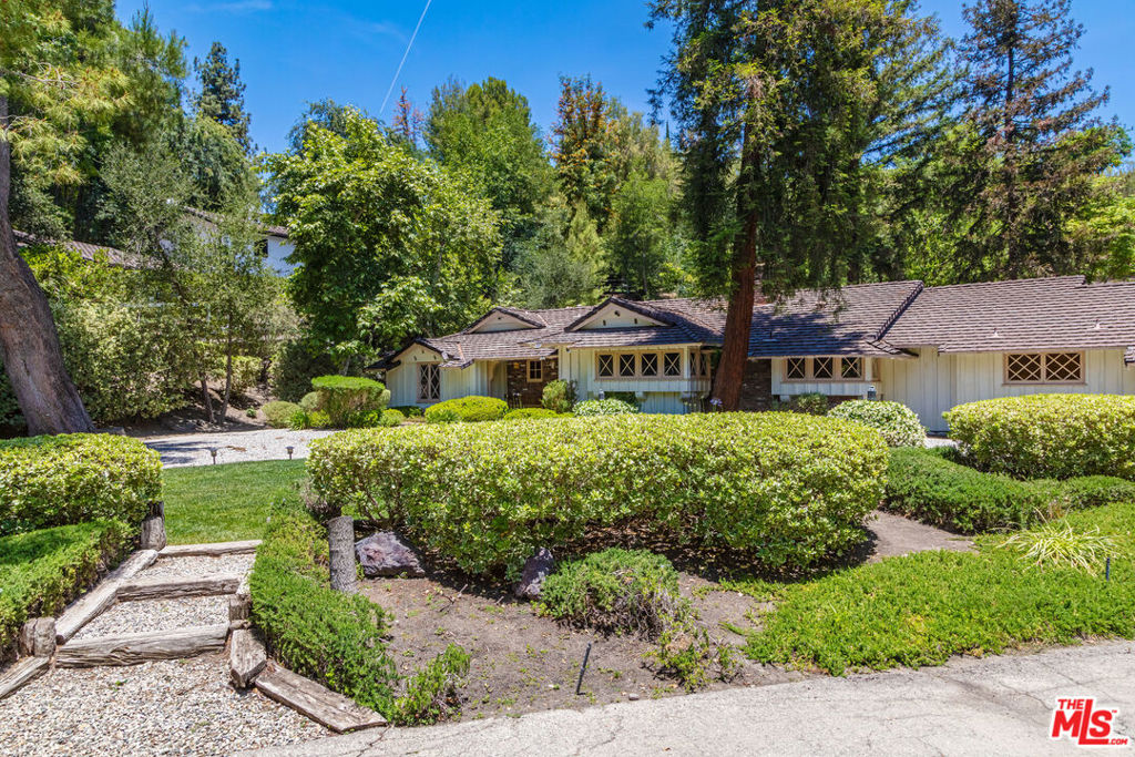 This charming ranch-style home is nestled on 2 serene acres filled with mature pine, sycamore, pomegranate, citrus, and California pepper trees. Privately located at the end of a secluded cul-de-sac within the prestigious, guard-gated Hidden Hills community, the property offers a peaceful, natural setting. The 3-bedroom, 3-bathroom residence features rustic touches throughout, including vaulted and exposed beam ceilings and a large antique brick fireplace in the living room. Expansive outdoor entertaining areas include a lush front yard and a vast backyard with a private horse trail. Just a short walk away are the community's pool, tennis courts, sports court, and theater allowing you to fully enjoy the Hidden Hills lifestyle. Ideal for end users looking to create their dream home or investors seeking a prime redevelopment opportunity.