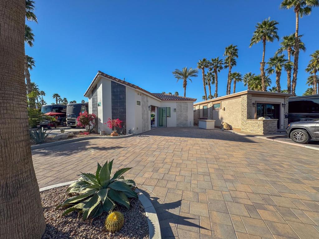 Outdoor Resort Indio is a class A only motorcoach resort. Nestled on the prestigious 7th tee box of Divot Lane, this exceptional luxury RV property offers an unparalleled blend of elegance, comfort, and breathtaking natural beauty. Boasting one of the largest lots in the resort at 3,920 sq. ft., this premier golf course retreat features an impressive 893 sq. ft. casita--one of the largest available--seamlessly designed for upscale indoor-outdoor living. Expansive glass doors open to a stunning 331 sq. ft. attached pergola, creating the perfect space to entertain or relax while soaking in the serene views of the lush fairways, cascading waterfall, and tranquil pond framed by majestic mountain vistas. The circular driveway provides ample parking for three cars and a golf cart, ensuring effortless convenience for both owners and guests.Inside, the exquisite kitchen is a chef's dream, adorned with luxurious quartz countertops, elegant shaker-style cabinetry, and a full suite of high-end appliances, including a refrigerator, sink, dishwasher, electric cooktop, oven, and microwave. The private bathroom features quartz countertops, a spacious vanity, and an oversized tiled shower for a spa-like experience. Dual split AC/heat pumps provide personalized climate control, while rear heaters on the patio ensure comfort on cool evenings. Situated in the heart of the vibrant Coachella Valley, this exclusive resort community offers world-class golf, pickleball, and an active, welcoming atmosphere for those who love luxury RV living at its finest. This extraordinary property is ready for you to bring your personal touch and begin living your dream in this stunning desert oasis.‍‍ Outdoor Resort Indio is a class A only motorcoach resort.