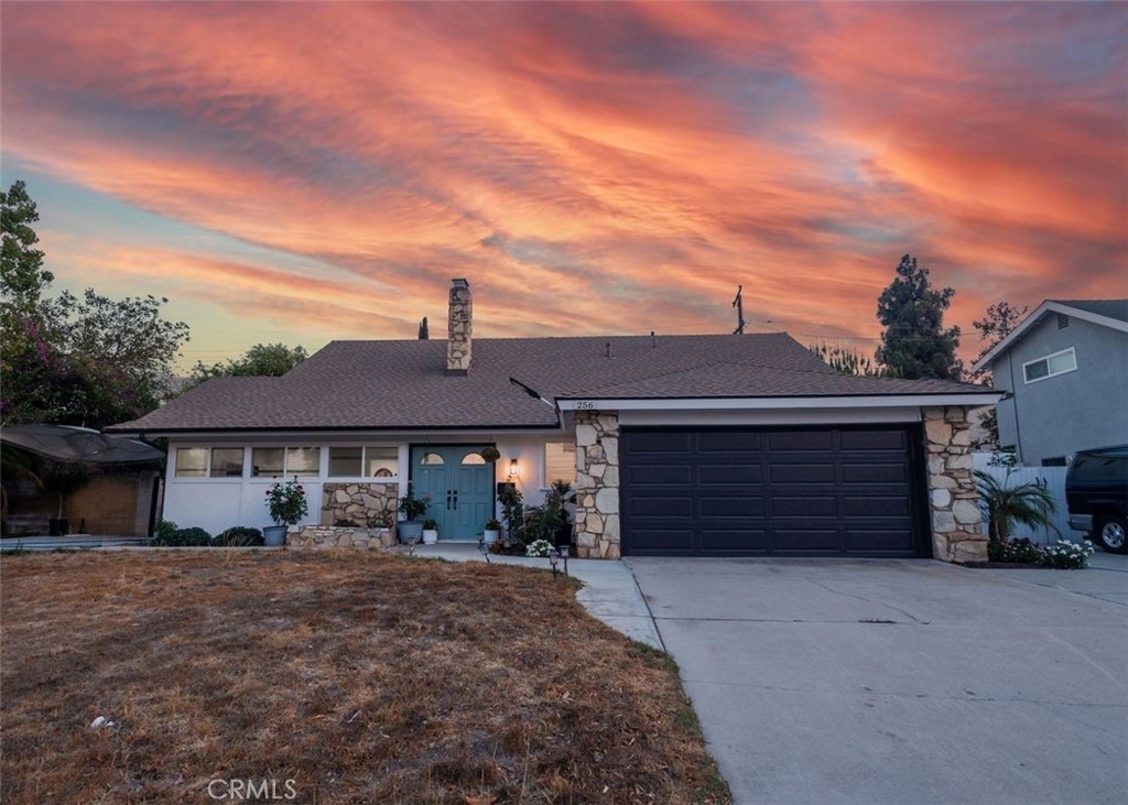 Welcome to a beautifully updated home in South Corona, crafted for both everyday comfort and quiet neighborhood living. This charming 4-bedroom, 2-bath residence spanning 1,578 sq ft and nestles on a generous 8,276 sq ft lot, offering both space and serenity. Steal into the light-filled living area enhanced by resilient laminate flooring, recessed lighting, and a statement fireplace with striking full-height tile surround. The fresh interior and exterior paint sets a bright, welcoming tone throughout. The kitchen boasts white cabinetry paired with sleek gray countertops, creating a modern yet timeless palette. Adjacent, an airy sunroom expands your living area which is deal as an extra lounge, reading nook, or informal dining space. Retreat to one ground-floor bedroom and bath making it perfect for guests or multigenerational living. Upstairs, discover three spacious bedrooms served by a convenient Jack-and-Jill bathroom. Newer carpeting and ceiling fans throughout elevate comfort and style. Outdoors, enjoy the expansive front and backyard spaces are perfect for gatherings, gardening, or relaxing under the California sun.