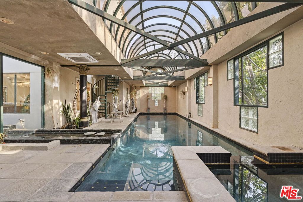 Welcome to The Deco House an iconic residence now available for lease in the prestigious Bird Streets. Nestled at the end of a quiet cul-de-sac, this 5-bedroom, 5-bath home offers approx. 4,303 square feet of elegant interiors and seamless indoor-outdoor living. A sweeping travertine staircase with a spectacular Lucite railing by celebrated designer Charles Hollis Jones anchors the entry and sets the tone for the home's Hollywood pedigree. Generously scaled living and dining areas open to sun-drenched patios, while mature landscaping creates a private backdrop around the dramatic pool pavilion. Perfect for entertaining or retreating in style, this residence blends architectural character with everyday comfort. Located moments from Sunset Boulevard yet tucked away in a serene enclave, *FULLY FURNISHED* Elegance and sophistication blend seamlessly in this warm, stylish rental home. A glamorous travertine staircase, highlighted by a striking Lucite railing crafted by the renowned Charles Hollis Jones, sets the tone for timeless luxury. Impeccably designed, the spacious rooms are perfectly suited for grand entertaining, while the inviting patios are framed by lush, mature landscaping. At the heart of the property, a dramatic pool pavilion offers a serene escape. This fully furnished home boasts an impressive array of amenities, including an indoor pool, a private gym, a Jacuzzi spa, skylights that bathe the interiors in natural light, and a relaxing sauna. Recently renovated, the property also features brand-new, extra-large bathrooms crafted entirely from exquisite Dekton and marble, upgraded electrical systems, and recessed lighting throughout, enhancing both functionality and ambiance. Nestled at the end of a tranquil cul-de-sac in the prestigious Bird Streets area, this home offers a rare opportunity to rent a flawlessly restored architectural masterpiece. The tenant is responsible for the utilies.