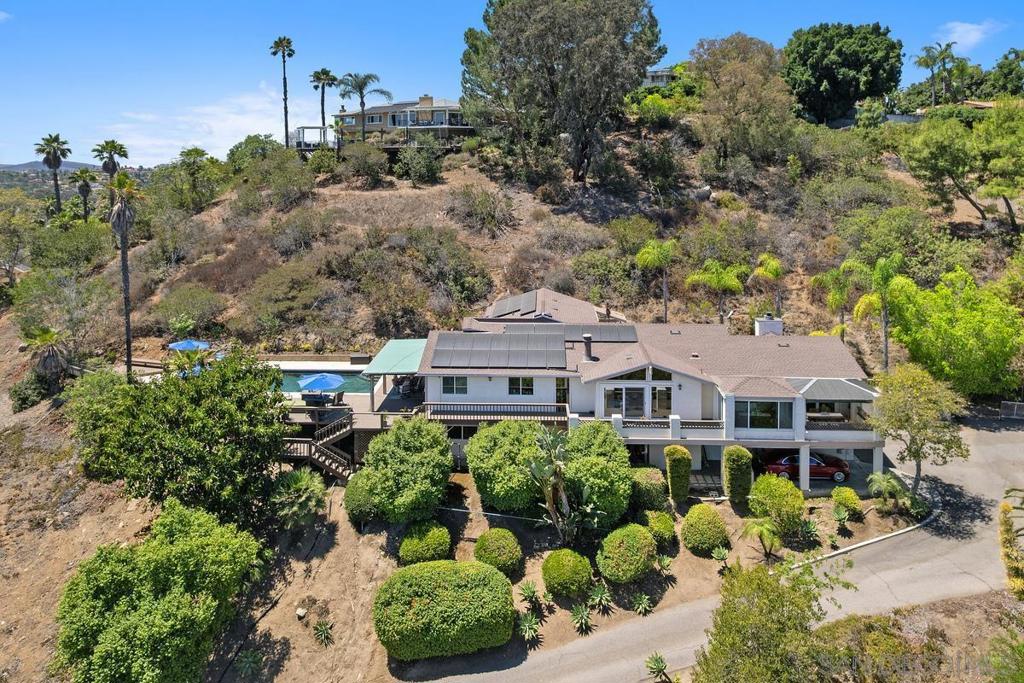 Welcome to this stunning hillside residence, where panoramic views and thoughtfully designed living spaces come together in perfect harmony. Nestled atop a scenic rise, this expansive home offers a rare blend of privacy, versatility, and year-round California indoor/outdoor living. Imagine coming home to sun-drenched living areas framed by large windows that capture sweeping vistas of the surrounding landscape. The kitchen is a true entertainer’s dream, seamlessly connecting to a covered outdoor dining area—ideal for al fresco meals with a view. Step outside to the pool deck and soak in the beauty of your surroundings, whether you're lounging under the sun or enjoying twilight gatherings. The primary retreat is a luxurious sanctuary featuring it's own deck, creating a tranquil space for rest and relaxation. Designed with flexibility in mind, the home's split-level layout is perfect for multigenerational living, offering privacy and comfort across multiple zones. Eco-conscious buyers will also appreciate the home's solar panels and EV charging station, providing energy efficiency and cost savings. Whether you're entertaining guests or enjoying peaceful mornings with a view, this home is a rare opportunity to own a slice of elevated paradise.
