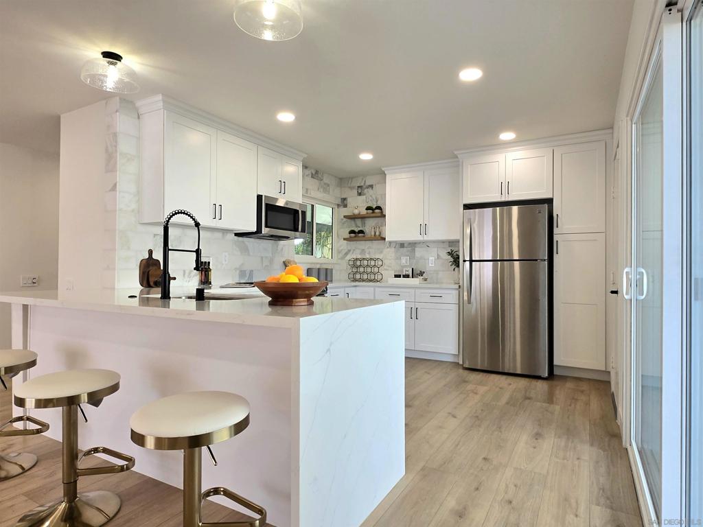 . Welcome to your practically Brand New home on Jaelene Street! Unique location with complete Privacy, Fully Mature Landscaping, and beautifully upgraded from the inside out. This home boasts a Brand NEW 5-ton LENNOX HVAC System, Newly replaced ROOF, and views of the San Jacinto Mountains. Step inside and you will discover an exceptionally LARGE almost 1800 sq ft. of Open Concept Living space flooded with tons of RECESSED lighting all on DIMMER switches even in the bedrooms! Gorgeous Textured Tiled fireplace, hearth and mantle, light oak flooring and WHITE DUAL PANE WINDOWS and SLIDER to keep your home comfortable all year long. The Kitchen is a chef's and entertainer's dream! Featuring a Center Facing Sink in the middle of the Peninsula, perfect for interacting with guests, White Shaker Soft Close Cabinets with a Pantry and * 2 * Lazy Susans, Complete WRAP Around Peninsula with WATERFALL Quartz Countertop and Airswitch, Honed Marble Backsplash wrapping all the way around the window finished with Floating Shelves and all new GE Stainless Steel Appliances including a Flat Top oven range, Microwave, Dishwasher and Refrigerator! Bedrooms feature recess lights on dimmer switches, LED Ceiling fans, a Walk-In closet in the Master Suite and mirrored closet doors in the 2nd bedroom. Both bathrooms are completely updated with new Fluted Wood Vanities, Mirrors, Lighting and a new FRAMELESS Chrome Shower Door in the Guest Bath, which has its own private access from the secondary bedroom, making it a potential secondary ensuite. 3rd room has a double door entry and can be used as an office or guest space. The Large INDOOR Laundry Room has plenty of Cabinetry and Countertop space for storage and folding, Honed Marble Backsplash matching the kitchen, newer Water Heater, and also includes LG Diamond Glass Edition Washer & Dryer. Rare enlarged 2 car garage with plenty of storage space and newer contemporary paneled garage door with windows. Fresh Interior and Exterior Paint complete with all new Modern Lighting, Security System, Extended Concrete driveway and backyard patio WITH drainage. Why settle for less? With way too many upgrades to list, this GEM checks ALL the boxes, MUST SEE true definition of finer living in Menifee's most desired 55+ Community with Low Taxes and Low HOA. One of a Kind.