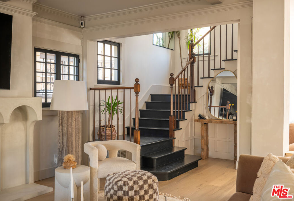 This Harvard Heights home blends Japandi design with Craftsman character, offering a main residence plus a detached guest house with its own kitchen, living space, bedroom, and full bath. Originally built in 1910 and fully remodeled in 2022, the property balances historic details like coffered ceilings, leaded glass windows, and wainscoting with modern updates including new oak floors, a plaster mantle, and a custom travertine kitchen with oversized island and breakfast nook. Upstairs offers a spacious primary suite with two custom closets, a lofted bonus space, and a marble-clad bath, plus 2 additional guest bedrooms with an updated full bath. The detached garage has been converted into a private gym, and the front yard includes a new gated parking space with automated entry. Extensive upgrades include new foundation work, windows, HVAC, electrical, and a Porsche EV charger. And when it's time to explore, you're only steps from neighborhood cafes and minutes from the vibrant dining scenes of West Adams and Mid-City.