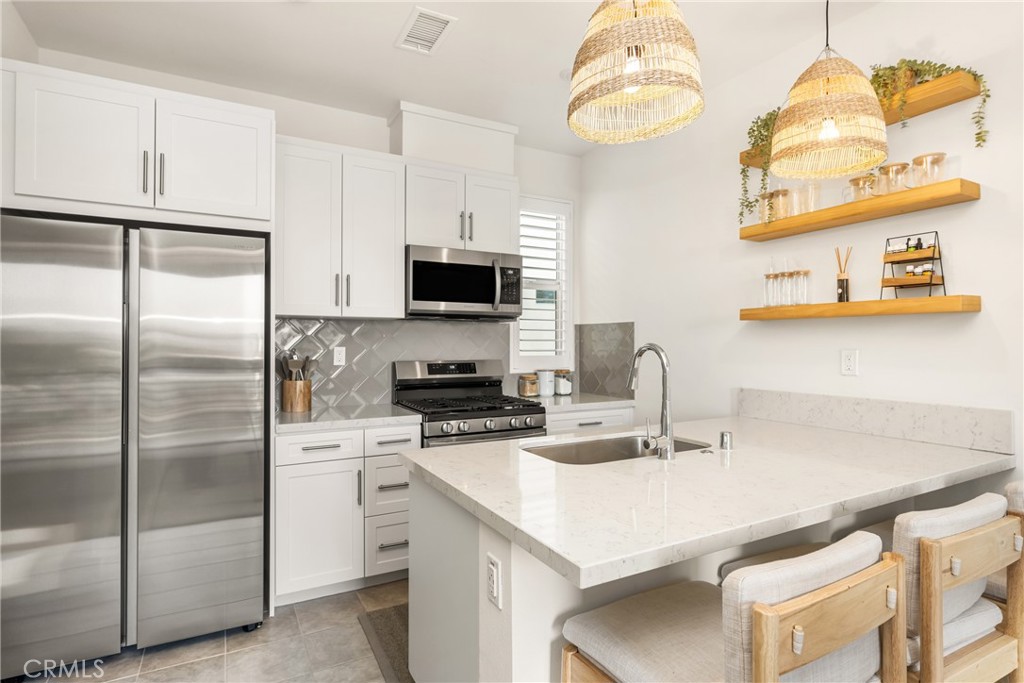 Welcome to this beautifully designed townhome located in the Hudson community of Placentia, built at the end of 2023 and completely move-in ready. Thoughtfully upgraded for energy efficiency, this home features paid-off, SELLER OWNED SOLAR panels, a tankless water heater, enhanced insulation, LED lighting, and energy-saving Smart Home components—helping you save significantly on your utility bills. Inside, enjoy the convenience of smart home features, including a connected thermostat, garage opener, dimming lights, and smart door lock. The open concept living area flows seamlessly to a private balcony through a sliding door with custom window coverings, offering indoor-outdoor comfort. The gourmet kitchen is equipped with Samsung stainless steel appliances, Including a refrigerator, dishwasher and microwave. You’ll love the quartz countertops, tile backsplash, tile flooring, white shaker cabinets with satin nickel bar pulls, an undermount sink, and a spacious walk-in pantry. The primary bedroom offers a relaxing retreat with high ceilings, recessed lighting and an oversized closet. The en-suite bathroom includes a step-in shower, tile flooring and quartz countertops. This home also includes an interior laundry area with washer and dryer included for your convenience. Additional highlights include plantation shutters, an oversized one-car garage with storage area and access to fantastic HOA amenities: a playground, basketball court, dog park, BBQ and picnic area, and outdoor fire pits. Located within the award-winning Placentia-Yorba Linda School District, and just minutes from shopping, dining, and entertainment.
Don’t miss your opportunity to live in this nearly new, energy-smart home in a thriving community!