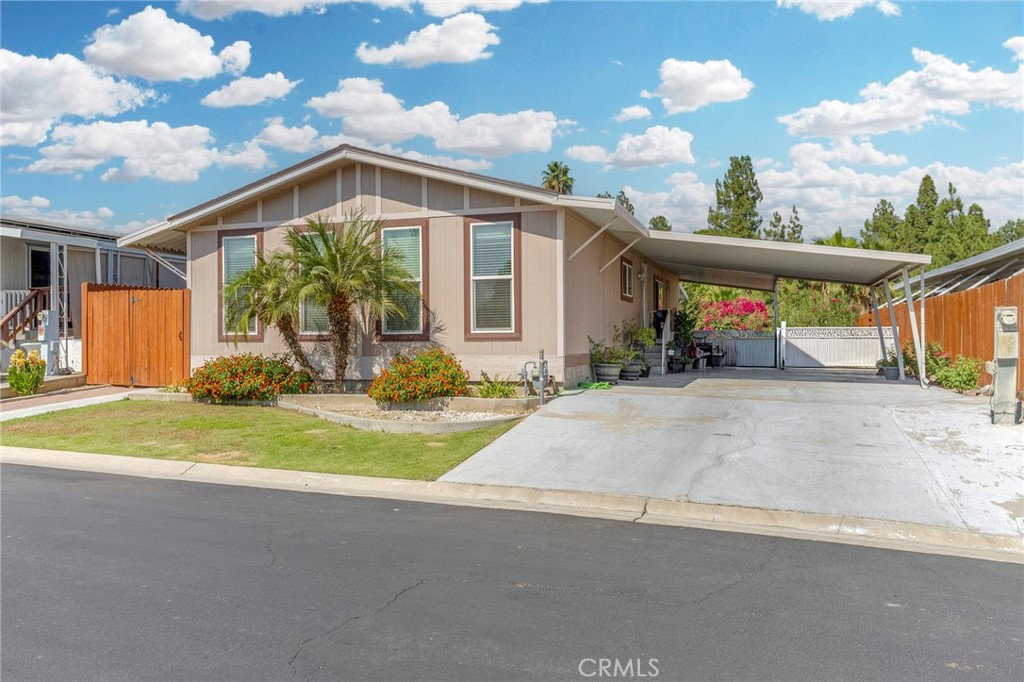 Charming 2-bedroom, 2-bath manufactured home on its own land, completely remodeled and move-in ready. This inviting property combines modern updates with a comfortable, open layout and thoughtful touches throughout. From the moment you step inside, you’ll notice the expansive feel created by high ceilings and abundant natural light pouring through new windows. Hardwood flooring flows seamlessly from the kitchen to the living and dining areas, enhancing the open-concept layout. Key features: Fully remodeled kitchen: white cabinetry, brand-new countertops, modern finishes, Open kitchen–living–dining space perfect for entertaining, Two spacious bedrooms with stylish barn doors on the closets, Two newly remodeled bathrooms: new cabinets, mirrors, toilets, hardwood flooring, and tile showers with updated fixtures, Indoor utility room for convenience, Newer HVAC (AC) system and brand-new roof for peace of mind, Fresh light fixtures and ceiling fans throughout, Manicured front and backyard with a beautiful deck for outdoor living, Large carport/driveway suitable for parking up to three cars. This home blends updated style with practical comfort, offering a low-maintenance, high-appeal living space in a desirable setting.