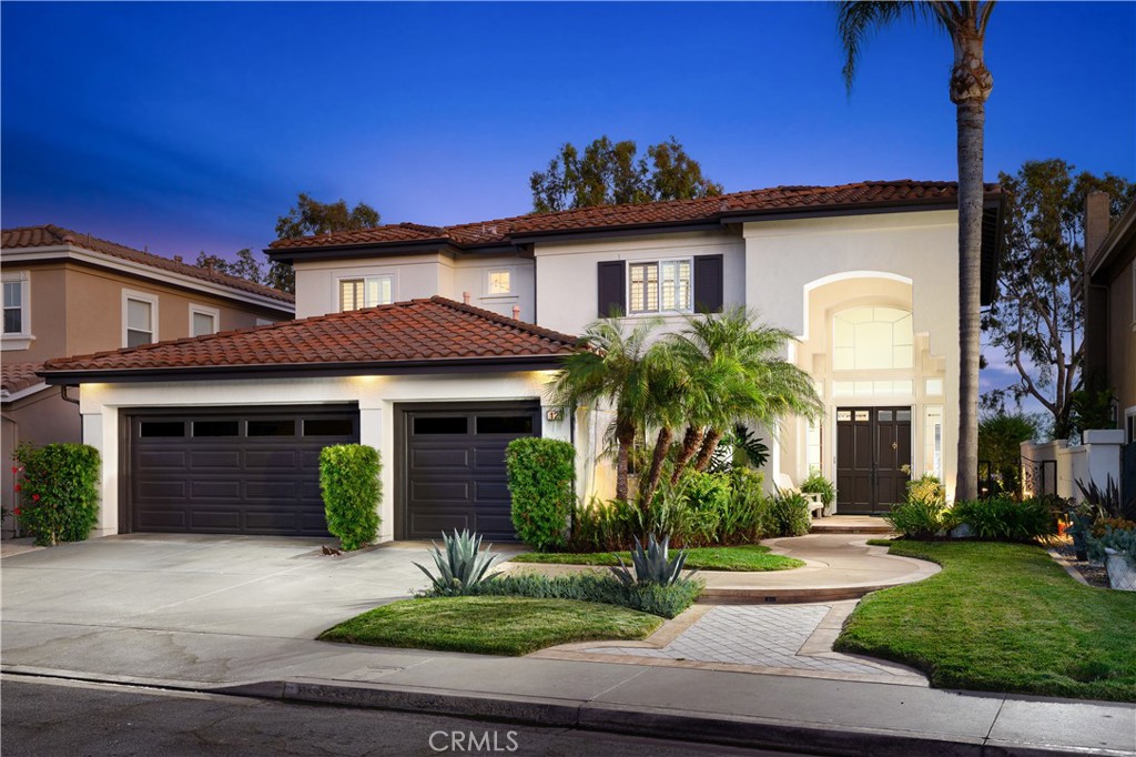 Built by the highly regarded JM Peters, this beautiful four bedroom, four bathroom home is located on a cul-de-sac street in the prestigious Paragon tract of Rancho Santa Margarita. With a view of the surrounding hills, the home offers a spacious and flexible floor plan, including a main-floor den or fourth bedroom. Inside, you’ll find elegant touches throughout, stone flooring, crown molding, plantation shutters, recessed lighting, and an abundance of natural light. The heart of the home is the gourmet kitchen, featuring granite countertops, espresso-colored cabinets with glass insets and under cabinet lighting, Thermador double ovens, a walk-in pantry, a center island, and stainless steel appliances. The kitchen opens to a welcoming family room complete with a custom entertainment center and a fireplace with stone surround, perfect for everyday living or entertaining. The main level also includes a formal dining room with large windows, which could be used as a living room, as well as a piano room that could serve as an additional dining area. Upstairs, the spacious primary suite offers a peaceful view of the hills and includes a separate retreat with a fireplace, ideal as a home office or reading nook. The spa-inspired primary bathroom is stunning, with dual vanities, white cabinetry, a chandelier, a freestanding soaking tub, a walk-in shower, and dual closets with elegant glass doors. Two additional upstairs bedrooms each feature their own tastefully remodeled en-suite bathrooms, offering privacy and comfort for family or guests. Additional highlights include a convenient downstairs laundry room with built-in cabinets, a sink, and side yard access; a three-car attached garage; a full PEX repipe for plumbing peace of mind; and a leased solar system for energy efficiency. The backyard is beautifully landscaped with custom hardscape, outdoor lighting, and serene hills view, an ideal space for relaxing or entertaining. Enjoy all that Rancho Santa Margarita has to offer, including access to the city’s incredible amenities: swimming pools, tennis courts, the Beach Club lagoon, the lake, scenic parks, community concerts, and more. This home is a perfect blend of comfort, quality, and lifestyle in one of South Orange County’s most sought-after neighborhoods.