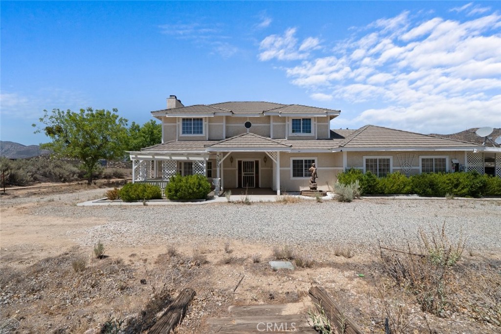 This beautiful 4-bedroom, 3-bathroom home offers approximately 2,800 square feet of living space on a private 5-acre lot with stunning mountain views. A covered front porch provides the perfect spot to relax and enjoy the peaceful surroundings. Inside, the home features a spacious formal living room with a fireplace and plenty of natural light. The kitchen has been upgraded with tile flooring and includes a large dining area, ideal for everyday meals and entertaining. The primary bedroom includes its own fireplace, wood flooring, a walk-in closet, a separate shower, and a private balcony overlooking the landscape. A downstairs bedroom with a full bathroom offers added convenience for guests or multi-generational living. Additional features include a laundry room and an attached two-car garage. With expansive land and a tranquil setting, this property offers the perfect blend of comfort, space, and privacy.