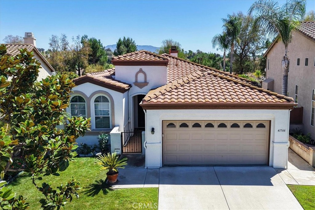 Honey, STOP the car! Welcome to 41766 Colonial Ct in Temecula, located in a quiet cul-de-sac directly across from the clubhouse within the beautiful Temeku Hills community. This 2-bedroom, 2-bathroom home also features a versatile bonus room that can easily be used as a third bedroom or office. As you enter, you're greeted by natural light and fresh neutral paint. To the left, you’ll find the secondary bedroom and full bathroom. Continue down the hallway into the spacious primary suite, which includes direct access to the backyard, a large walk-in closet, and a beautifully upgraded en-suite bathroom featuring quartz countertops, dual sinks, a vanity area with a full-wall mirror, a walk-in shower, a separate soaking tub, and a private toilet room. The kitchen is bright and open with a skylight, Corian countertops, and plenty of cabinet space, and it opens directly to the family room so you’re always part of the conversation. In the kitchen, you’ll find the walk-in pantry, the door to the laundry room, and just beyond that, access to the garage creating a smart and functional layout for daily living. The family room features a cozy fireplace perfect for crisp fall mornings, and a nearby door leads out to the backyard where you’ll enjoy a peaceful setting with breathtaking sunrise views over the city and surrounding hills. The bonus room near the living area includes a full-sized built-in desk and shelves, making it ideal for a home office or third bedroom if needed. The home features laminate and tile flooring throughout, an alumawood patio cover for shaded outdoor relaxation, and vinyl fencing for added privacy. Enjoy the peaceful lifestyle Temeku Hills offers along with community amenities like a golf course, tennis courts, clubhouse, pool, spa, and more. This home is a must see!