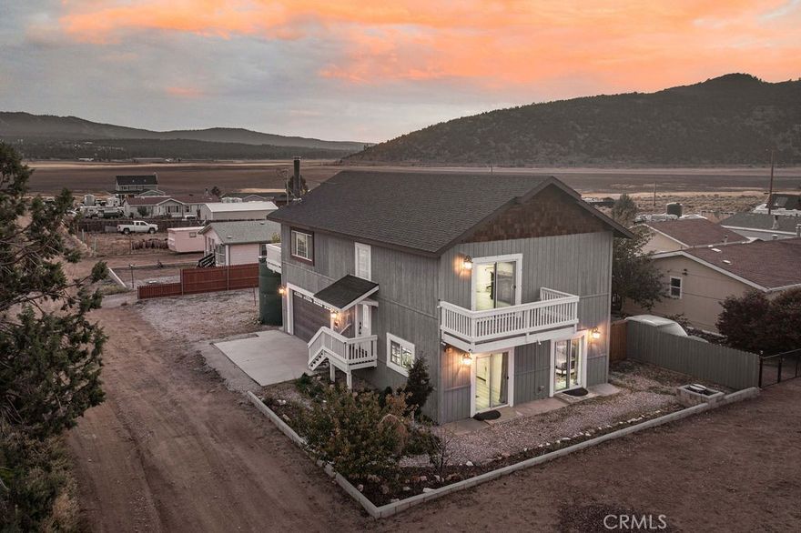 Panoramic mountain and ski slope views! Built in 2008 and recently remodeled, this beautifully updated home blends modern design, comfort, and year-round mountain beauty. It captures stunning views of Snow Summit, Bear Mountain, and the surrounding ranges from nearly every window. Step inside to a light-filled open floor plan where large dual-pane windows fill the living area with natural light. The space flows seamlessly into the dining area and upgraded kitchen, featuring tons of cabinet storage space, granite countertops, stainless steel appliances, and a spacious center island perfect for gathering. Enjoy cozy evenings by the freestanding wood-burning stove or start your mornings on the upper deck with coffee as the sun rises over the mountains. The oversized upstairs primary suite offers a private retreat an en suite bathroom with a deep soaking tub, and a walk-in closet. Sliding doors open to a private balcony overlooking the valley, the perfect spot to unwind and take in the scenery. On the lower level, two additional bedrooms provide generous space for family and guests, along with a full bath, laundry room, and garage access. An extra-deep two-car garage, currently designed as a game room with foosball and air hockey tables; offering a great space for fun or flexible use as a gym, studio, or workshop. Outside is a large fenced yard with mature fruit trees. The home also features a tankless water heater, and plenty of parking for guests or recreational vehicles. Located just minutes from Big Bear Lake, ski resorts, and miles of hiking trails, this remodeled mountain home offers the perfect blend of peaceful seclusion and convenience. Whether you’re seeking a full-time residence, weekend escape, or investment, this is a great home!