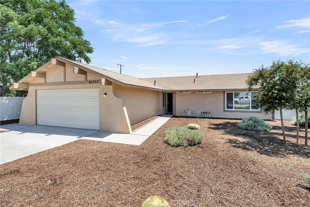 Welcome to 24933 Dracaea —a 4-bedroom, 2-bath single-story home that has been updated throughout with neutral colors and a clean aesthetic. Set behind a low-maintenance, drought-tolerant front yard, this residence offers strong curb appeal with its clean lines, dual pane windows, and recently painted stucco finish. Inside, the home showcases a recently remodeled kitchen featuring granite countertops, white shaker-style cabinetry, a dual-basin stainless steel sink, and black appliances. Durable vinyl plank flooring runs throughout, complementing the bright, neutral palette and enhancing the natural light that floods each room. The primary suite lies on the opposing side of the hallway from the secondary bedrooms and includes an ensuite bathroom with an updated vanity and a walk-in shower. Three additional bedrooms offer flexibility for family, guests, or a home office. Outside, the expansive lawn in the backyard offers ample space for entertaining or recreation while offering a pleasant greenbelt view for the large patio with an alumawood patio cover. Extending directly from the family room, the patio provides the perfect shaded area for outdoor dining or gatherings. Additional amenities include central HVAC, dual-pane windows, a two-car garage, and a private gated driveway. Move-in ready and thoughtfully updated; take a look today.