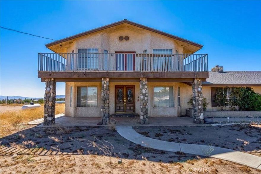Welcome to your own peaceful slice of the desert! This spacious 2,712 sq ft home sits on 2 flat acres with stunning views and room to roam. With 4 bedrooms and 3 bathrooms, there’s plenty of space for everyone to spread out and feel right at home. Step inside to find a bright, open layout with stylish laminate and stone tile floors, recessed lighting, and tons of storage. The kitchen is a true standout—featuring warm wood cabinets, granite countertops, a big center island with breakfast bar, built-in appliances, and even a little office nook. There’s also a separate dining room that’s great for gatherings. Upstairs, the huge primary suite feels like a retreat, complete with a cozy fireplace lounge, private balcony, walk-in closet, and a spa-like bathroom with a soaking tub and double sinks. Natural light flows in through French doors throughout the home, making every room feel warm and inviting. Outside, enjoy the quiet from your covered back porch or soak up the sun on the open patio while taking in those beautiful mountain views. There’s also an oversized 6-car garage—plenty of room for cars, toys, or even a workshop. Just a short 12-minute drive to Target, Walmart, restaurants, schools, and the 15 freeway—this home combines privacy and convenience in one incredible package. Come see it for yourself!