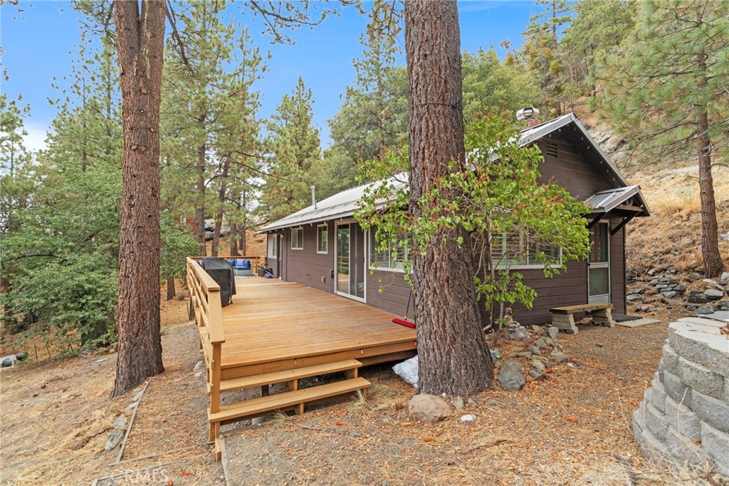 Welcome to 2080 Mojave Scenic Dr! This charming 2-bedroom, 1-bath home has been lovingly cared for and it shows the moment you walk in. The light-filled living room features wood flooring, wood-beamed high ceilings, and a cozy fireplace. The open-concept kitchen highlights custom cabinetry, retro appliances, and a vintage sink with plenty of character. The larger bedroom offers oversized windows and direct access to the deck, while the secondary bedroom includes a convenient stackable washer/dryer. A newly installed mini-split A/C unit provides year-round comfort. Step outside to the oversized wooden deck—perfect for creating your dream outdoor living space, all surrounded by nature and mountain views. Two off-street parking spaces complete this must-see property!