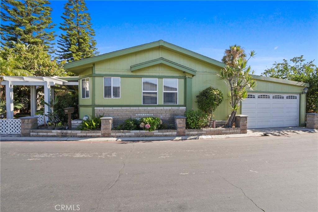 A home very distinctive from all the others for many reasons. It’s a ground-level residence, no stairs. Second, its oversized lot is spacious w/a quaintly fenced-in yard featuring a built-in fountain, gas BBQ, grass, beautiful trees that offer shade and privacy. Built in 1995, this 1782 sq ft home (1,982 counting attached storage in the garage) it offers a well-designed layout with 3 bedrooms & 2.5 bathrooms, a family room, formal living room with a stunning gas-burning fireplace of stucco/tile with a mantle-to-ceiling mirror, bringing warmth & depth to the room. It has a formal dining area adjacent to the formal living area with a pass-through space between the dining room and kitchen. The open floor plan creates a seamless flow throughout the home, enhanced by abundant natural light pouring in through multiple skylights & generously sized windows. The kitchen is spacious enough for multiple helpers during special occasions, & island large enough for seating at the end. Adjacent to the kitchen, the family room provides ample space for an additional dining area as well as plenty of space to relax as a family. All 3 bedrooms are generously sized & have walk-in closets. The 1st & 2nd bedrooms are connected by a Jack & Jill bathroom, & include a stall shower with a sitting bench. The 2nd bedroom features double doors & a custom-built-in workstation (which can be removed if desired). The primary suite is generously sized, with a separate walk-in closet just off the primary bath, which includes a Roman-style tub & a separate stall shower. Additional features of this home include two skylights with retractable blinds in the family room, a laundry room with a half bath, 2 water heaters,wood-look laminate flooring, water purification system, 6 security cameras, tube skylight, an automatic sprinkler & drip system, low-voltage accent lighting, A/C PLUS an extra window A/C, & several free-standing plants. This home truly is a sanctuary—a must-see for anyone seeking comfort, style, & functionality. This home is located at the prestigious Anaheim Shores Estates. This park is unlike other manufactured home parks as it offers so many benefits, such as extra-wide streets, it's pet-friendly, has well-maintained trees & shrubs, a community pool, spa, bbq area, clubhouse, & a grass area for pets. The clubhouse offers a venue to enjoy many different occasions. They also have a billiards room, card game room, a library, a TV room, & a kitchen.