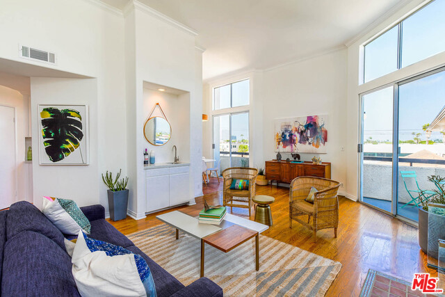 Dramatic top corner floor unit with 12' ceilings and views of DTLA! This remodeled 2 BD+2 BA feels like a home - with a formal entryway leading to an open living/dining room flooded with natural light. Modernized clean white galley kitchen. Master suite with balcony, abundant closet space and a luxurious bath with dual vanities and separate shower/tub. Also featuring: wood floors throughout, laundry room with side-by-side units, 3 balconies, newer HVAC and water heater, extra storage locker and 2-car tandem secure parking. Live in the heart of the city, near dozens of shops and restaurants with a Walkscore of 83!