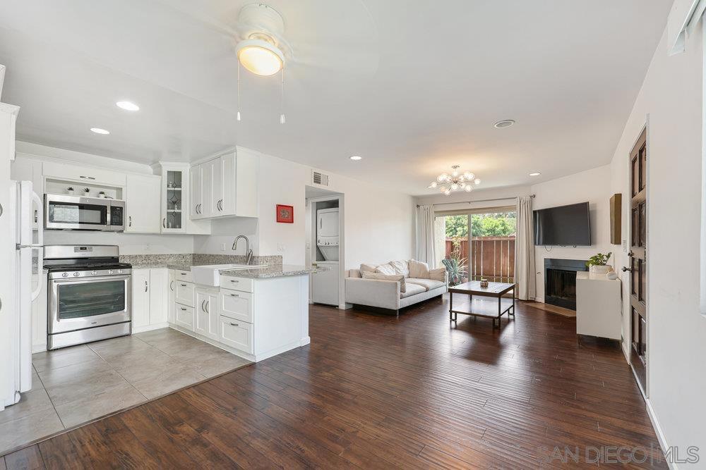 Welcome to this beautifully upgraded downstairs condo, offering 2 bedrooms and 2 bathrooms in a bright, open layout designed for both comfort and style. The kitchen shines with granite countertops, custom cabinetry, and ample workspace for everyday cooking or entertaining. The inviting living room is anchored by a cozy fireplace and flows seamlessly onto a private patio—perfect for morning coffee or evening relaxation. Inside, you’ll find rich laminate flooring, upgraded windows that fill the space with natural light, and a convenient in-unit laundry closet with a stacked washer and dryer. Both bathrooms have been fully remodeled with fresh, modern finishes that create a spa-like feel. The oversized primary suite is a true retreat, featuring a custom built-in wardrobe system with thoughtfully designed cabinets and drawers for maximum storage and organization. This home also includes a private attached garage with direct entry into the residence, plus TWO additional community parking spaces—an excellent combination of convenience and security. The community offers resort-style amenities, including a sparkling pool and a relaxing spa. The location is ideal: just off the 805 freeway, providing easy access to the highway, shopping, dining, and everyday conveniences. Move-in ready and thoughtfully updated, this condo perfectly blends comfort, convenience, and modern style—don’t miss the chance to make it yours!