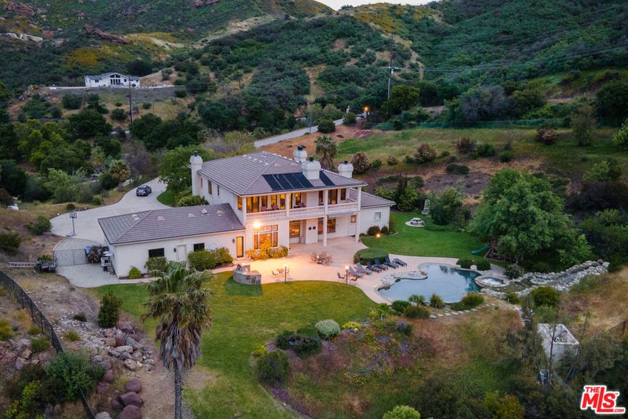 Tucked away in the serene hills of Malibu's breathtaking canyons, stands as one of California's most distinguished and private residential estates. This gated compound offers unmatched seclusion amid beautifully landscaped grounds and showcases unobstructed panoramic views of  Boney Ridge, Sandstone Peak. Spanning approximately 11 acres, the 6,734 sq. ft. residence features 6 bedrooms and 7 bathrooms, blending refined luxury with timeless architecture. A grand portico entry welcomes you into a dramatic great room and soaring 24-foot ceilings, setting the tone for the home's elegant scale. High-end finishes are found throughout, including an expansive primary suite with a private sauna, a resort-style pool and spa with cascading waterfall, and a three-car garage designed to accommodate a boat or RV. With ample space to add an ADU, this property offers endless possibilities for those seeking privacy, sophistication, and natural beauty in Malibu's most scenic setting.