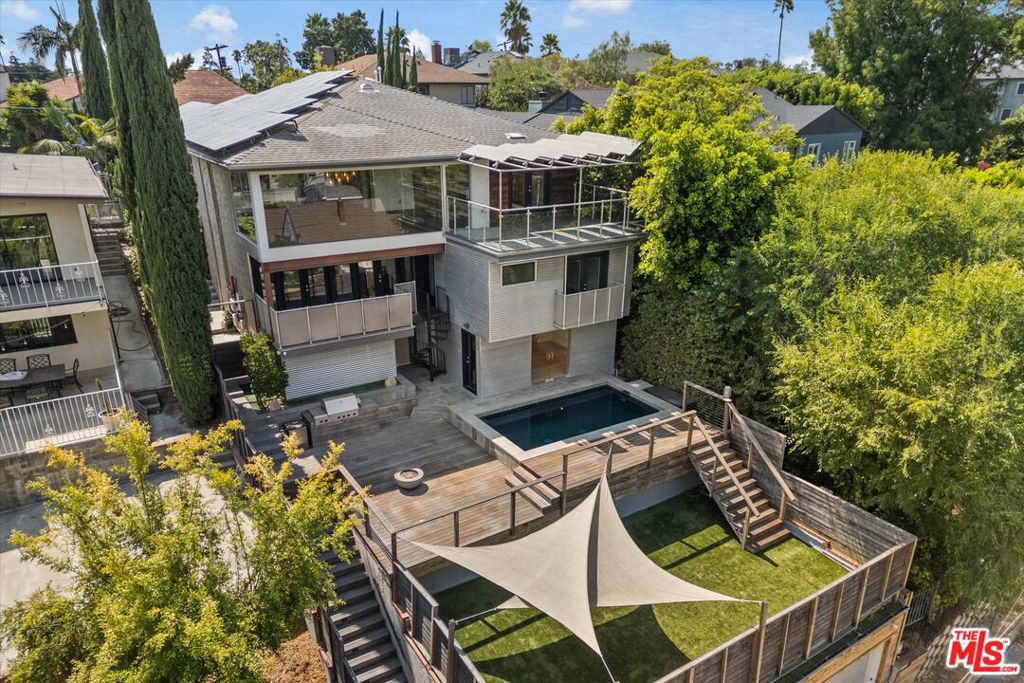 Set on a private cul-de-sac in Franklin Hills, this expansive 6-bedroom, 5-bathroom home offers sweeping 180-degree views and a versatile layout designed for both everyday living and entertaining. The main level features a well-appointed kitchen and an open living and dining area with floor-to-ceiling glass windows, framing breathtaking vistas. Two bedrooms and two bathrooms are located on this floor, including the primary suite with direct balcony access, a walk-in closet, and a spa-like bath with a jacuzzi tub. On the lower level, a second living room/den opens to another balcony and connects to four additional bedrooms, two bathrooms, a laundry area, and a spacious bonus room ideal for a theater, playroom, or extra storage. Outdoor living is at its best with a pool and deck area complete with BBQ grill and fire pit, as well as a pool house guest suite featuring its own bathroom with a steam and rain shower. Below the pool, a flat yard offers even more space for lounging or stargazing. The home sits on a rare through-lot with a 4-car lower garage accessible from Ames Street (in addition to the one-car garage attached to the main level), perfect for more parking or a home gym. Additional highlights include solar panels, dual HVAC systems, and a location within the sought-after Franklin Avenue Elementary School District. With easy access to Los Feliz Village, Griffith Park, DTLA, and the Hollywood studios, this home brings together privacy, scale, and convenience in one remarkable setting.
