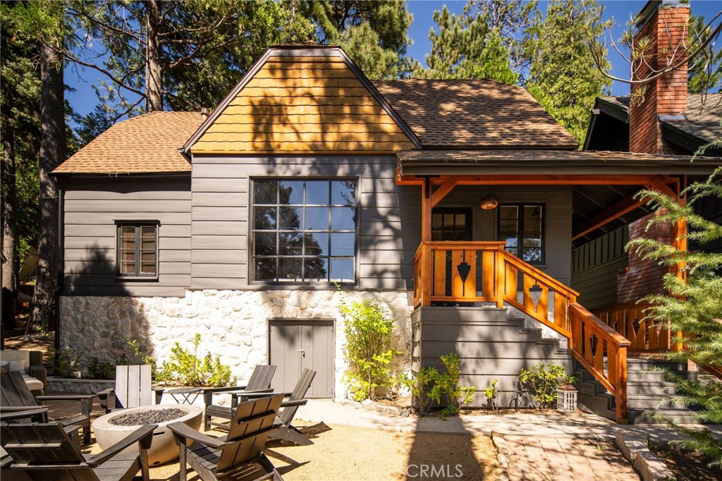 Timeless charm meets modern design in this beautifully remodeled mountain retreat, ideally situated just across the street from the lake in Lake Arrowhead’s sought-after Palisades neighborhood. Step inside to a warm and inviting main living space that blends vintage character with curated style. Floor-to-ceiling windows bring in natural light and frame views of the trees, while original wood-beamed ceilings and knotty pine paneling add cozy, mountain-lodge character. Two distinct seating areas provide room to relax or entertain, all anchored by a stunning original stone fireplace. The kitchen is both functional and full of personality, featuring playful two-tone green cabinetry, classic finishes, and a built-in dining nook with a farmhouse table. Indoor-outdoor access makes for effortless entertaining and easy flow between spaces—perfect for life in the mountains. Two beautifully remodeled bathrooms and cheerful, light-filled bedrooms offer comfort and charm in equal measure, creating a welcoming retreat for family, friends, or guests. Step outside to an expansive decomposed granite and stone patio, thoughtfully designed for outdoor living and entertaining. Multiple zones provide room to dine, lounge, and play—from casual meals under the trees to evenings around the fire pit or games in the open recreation space. A rare two-car garage adds valuable convenience.Whether you're looking for a full-time residence, a design-forward getaway, or a proven investment, 117 John Muir Road checks every box. The home also operates as a luxury short-term rental, offering strong income potential in one of Lake Arrowhead’s most desirable enclaves. Amenities also include Air Conditioning and a whole house generator.
