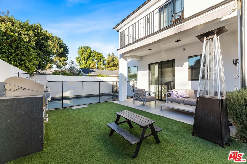Welcome to your Tarzana dream home- a gated modern masterpiece designed for comfort and luxury. This sunlit home boasts 4 spacious bedrooms, including a grand master suite with a king-sized bed, balcony, and a huge walk-in closet. Two additional upstairs bedrooms feature twin beds and large walk-in closets, while the downstairs bedroom offers a cozy queen bed. With 4 full bathrooms and a powder room, convenience is at your fingertips. Enjoy your space in style with the open-concept living and dining area, complete with hardwood floors, recessed lighting, and a gas fireplace. The gourmet kitchen features high-end KitchenAid appliances, a dishwasher, and a dining table that seats 8. All rooms are equipped with Smart TVs and blackout blinds for ultimate relaxation. Step outside to your private oasis. The backyard offers a pool and hot tub with a safety fence, a covered patio with an outdoor heater, a BBQ pit, and artificial turf for low-maintenance elegance. Sports enthusiasts will love the full-court basketball setup. Additional features include a smart home heating system, a laundry room with a full-sized washer and dryer, a small office under the stairs, and a camera security system with intercom.This home is a perfect blend of modern design and functional living, ideal for families and entertainers alike. Don't miss this rare Tarzana gem!