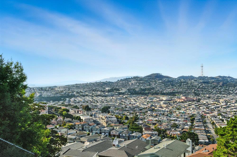 Sweeping San Francisco & Bay Views in Daly City's Southern Hills! Nestled in Daly Citys desirable Southern Hills, 46 Caroline Way combines breathtaking views with versatile living spaces and move-in ready comfort. This 3-bedroom, 2-bathroom home offers approx. 1,400 sq. ft. on a 6,149 sq. ft. lot with a main-level balcony and ground-level patio showcasing sweeping, unobstructed views of the Pacific Ocean, Bay Bridge, San Francisco Bay, and City skyline. The spacious living/dining room features a wood-burning fireplace and French doors to the balcony, while the updated kitchen includes new flooring, painted cabinetry, and modern fixtures. Hardwood floors add warmth throughout. Two bedrooms and a full bath with stall shower and separate tub complete the main level. Downstairs, a large third bedroom with renovated bath and private entrance offers flexibility for an in-law suite, guest space, or family room. Outdoor living is highlighted by an expansive deck, paver patio, and concrete planter walls. Freshly painted interiors, double-pane windows, and generous parking (four spaces plus street) add ease. With convenient access to BART, I-280/101, shopping, parks, and San Francisco, this home blends panoramic views with updated interiors, indoor-outdoor flow, and flexible living spaces.