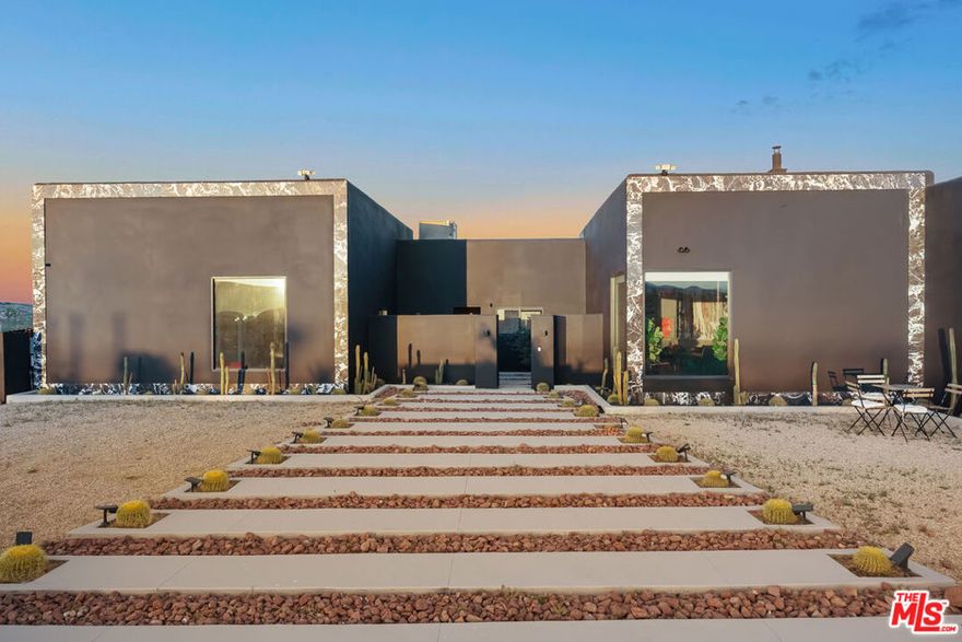 Welcome to your private sanctuary in the heart of Joshua Tree- a striking 4-bedroom, 3-bath architectural gem, which was extensively re-imagined in 2022, that fuses modern luxury with dramatic desert flair. Set against panoramic Mojave views, this custom-built home offers a one-of-a-kind layout, wrapped in a sleek black fade with shimmering metallic accents. Step inside to discover a bold and curated interior each bedroom uniquely designed with vibrant mural walls, upscale finishes, and gallery-quality art. The luxe primary suite boasts a marble-clad spa shower, oversized picture window, and private desert views. Luxury statement tile run throughout, offering durability with high design. Outdoors, enjoy the ultimate entertainer's layout: a sleek black-bottom pool with spa, expansive patio with loungers, and a fire pit lounge perfect for stargazing nights. Cactus-lined paths guide you through the xeriscaped landscape, blending luxury living with rugged natural beauty. Additional highlights include: a chef's kitchen, custom lighting, oversized garage, connected to public sewer/water, and high-end finishes throughout. Located minutes from Joshua Tree National Park yet offering total privacy this home is ideal as a primary residence, design-forward getaway, or high-end short-term rental. Experience the desert elevated.
