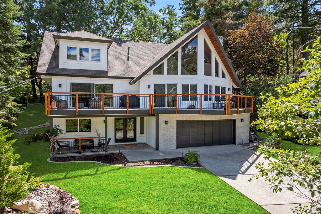 Sitting in the pristine alpine community of Lake Arrowhead (Lake Rights), on a cul-de-sac street, this home invites you into a world where the rhythm of the seasons & the serenity of the forest become part of your daily life. Lake Arrowhead, with So. Cal’s only private alpine lake, is not just a destination but a lifestyle reserved for the fortunate few. This remarkable property, just 3 doors from the entrance to the Lake Arrowhead CC golf course & directly across from the expanse of the national forest, offers the best of both worlds—endless adventure and peaceful retreat. Architecturally striking, the home is designed in the timeless & most beloved "Prow" style, its soaring cathedral ceilings drawing the eye upward while the dramatic “wall of glass” opens the heart to breathtaking views of the trees. Each sunrise pours golden light through the glass, casting warmth across the open great room, while evenings bring the glow of the fireplace and the hush of the forest settling in around you. Over $250K in recent improvements ensure that the home blends modern convenience with its authentic alpine character, include Brand-new siding, 2 new A/C units & an expansive entertaining deck that extends your living space into the outdoors, perfect for twilight dinners under the stars or lazy afternoons among the pines. Inside, the kitchen gleams with new appliances, ready for gourmet meals or cozy family breakfasts, while some new flooring completes the sense of renewal. With 4 Brms & 2.5 bas, there is space for everyone—whether it’s a romantic retreat for two or a gathering place for friends and family. Each room whispers its own story, with natural light filtering through tall windows and quiet corners waiting for laughter, conversation, & memory-making. The attached 2-car garage adds convenience while also holding the promise of alpine adventures—skiing in winter, sailing, paddleboarding & waterskiing in summer, & year round hiking!. Offered turn-key furnished, this property becomes not just a house but an effortless invitation to begin your Lake Arrowhead story immediately. Imagine weekends strolling to the golf course, mornings wandering into the forest trails just across the way, afternoons spent at the lake, and evenings filled with the warmth of family & friends gathered under the cathedral ceilings of your very own mountain retreat. This is more than a home—it is a love letter to the alpine lifestyle, waiting for its next chapter to be written by you.