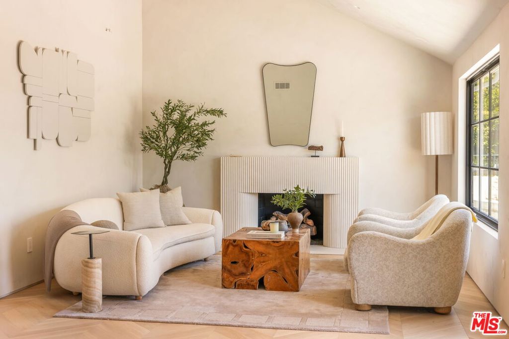 Tucked into the serene hills above the Sunset Strip by Chateau Marmont, this thoughtfully reimagined residence blends refined materials with modern livability. The interiors are wrapped in Portola limewash, lending warmth and depth to every space. At the heart of the living room, a custom travertine gas fireplace offers an understated focal point, balancing elegance with comfort. Generous outdoor spaces anchor each end of the home, with a south-facing lounge framing sweeping city views and inviting seamless indoor-outdoor living. The kitchen pairs solid oak cabinetry with Thermador appliances, anchored by striking leathered Taj Mahal stone countertops. The bathrooms are adorned with large-format porcelain slabs, along with custom integrated sinks and vanities. Underfoot, engineered European oak chevron floors bring a sense of rhythm and continuity throughout the home. The property is pre-wired for speakers in both the three-bedroom main house and the ADU. All this, only moments from the world class shopping and dining that West Hollywood and Beverly Hills have to offer.