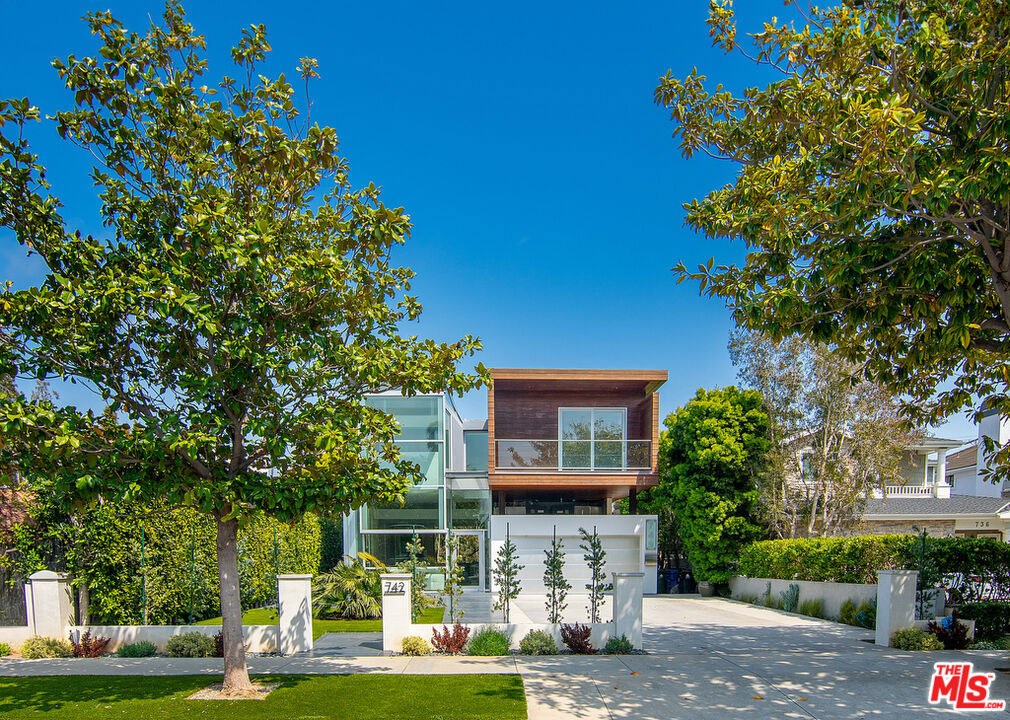 Presenting the Via De La Paz Residence, a stunning architectural home in the heart of Pacific Palisades. Perfectly situated on one of the best streets, the home is nestled between the water and the mountains, short distance to the Pacific Ocean, the Bluffs, and the hiking trails of Temescal Canyon. In addition to its immediate proximity to a number of private and public schools, the La Paz Residence is minutes to the neighborhood's upscale Palisades Village, home to fine dining, boutique shops, movie theater, exercise studios, and grocery stores. The La Paz Residence offers the epitome of the Southern California fresh air indoor/outdoor living lifestyle. The all-glass front opens to soaring 13-ft. ceilings in an open floor plan that continues throughout the house and leads to beautifully customized floor-to-ceiling glass OTIIMA doors that span the entire width of the house. The house includes a gourmet chef's kitchen with a massive 8' x 10' center island with seating for 6, all surrounded by premier appliances which include a BlueStar 10-burner gas stove top, a 6-ft. wide Dacor stainless steel Fridge/Freezer, double ovens, double warming trays, and four pull-drawer Fisher & Paykel dishwashers. The center island also includes two additional Sub-Zero under counter drinks drawers as well as significant storage space. The home has 4 bedrooms and 1 office, all of which are ensuite. In addition, there is a detached below-ground en-suite living space, which can be used as guest quarters, office, music studio, games room, or additional entertainment room.