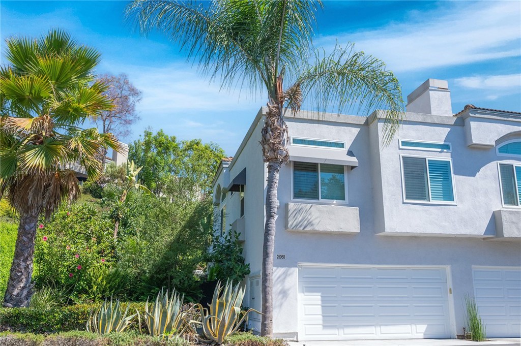 Welcome to this beautifully updated, move-in ready end-unit townhome in Laguna Niguel’s coveted Mirador community. Framed by a lush wraparound yard, the home immediately invites outdoor living—mature fruit trees, tropical landscaping, and thoughtfully designed seating areas create a private garden retreat that feels both tranquil and indulgent.
Inside, natural light fills the thoughtfully upgraded interior, where the kitchen flows seamlessly into the dining and living areas—perfect for everyday life and effortless entertaining. Crisp quartz countertops, a marble tile backsplash, soft-close cabinetry, and an expanded layout elevate the heart of the home. The living room offers peaceful yard views, a slate-framed gas fireplace, and clean lines thanks to custom wall-concealed TV wiring.
A flexible downstairs bedroom—ideal for guests, a home office, or a true third bedroom—overlooks the garden and sits adjacent to a full bath with a frameless glass shower and marble-style porcelain tile, blending coastal charm with contemporary elegance.
Upstairs, the primary suite features soaring ceilings, dual closets including a walk-in, and a dual-sink vanity with granite counters and coordinated tile finishes. The secondary suite offers comfort and style with plantation shutters, a ceiling fan, and a chic ensuite bath with quartz counters and designer details.
Upgrades throughout include Simonton dual-pane windows, wood-look flooring, LED recessed lighting, high-efficiency toilets, plantation shutters, and a newer HVAC system with booster fans for enhanced upstairs climate control.
The professionally designed wraparound yard is both serene and smart. Meyer lemon, tangelo, passionfruit, fig, apricot, plum, olive, and loquat trees surround multiple seating zones, while a smart B-hyve irrigation system automates watering for pots, planters, and even fountains—luxury living with ease.
The attached two-car garage offers washer/dryer hookups, custom cabinetry, a deep utility sink, and generous storage.
The HOA covers water, trash, exterior maintenance, roof, termite coverage, structural insurance, and access to the community pool and spa—providing peace of mind and simplifying everyday living.
Residents enjoy close proximity to award-winning schools, hiking trails, premier golf, dining, and world-class beaches. From sunlit mornings in the garden to golden hour walks along the coast, this is Laguna Niguel living at its finest. Welcome home.