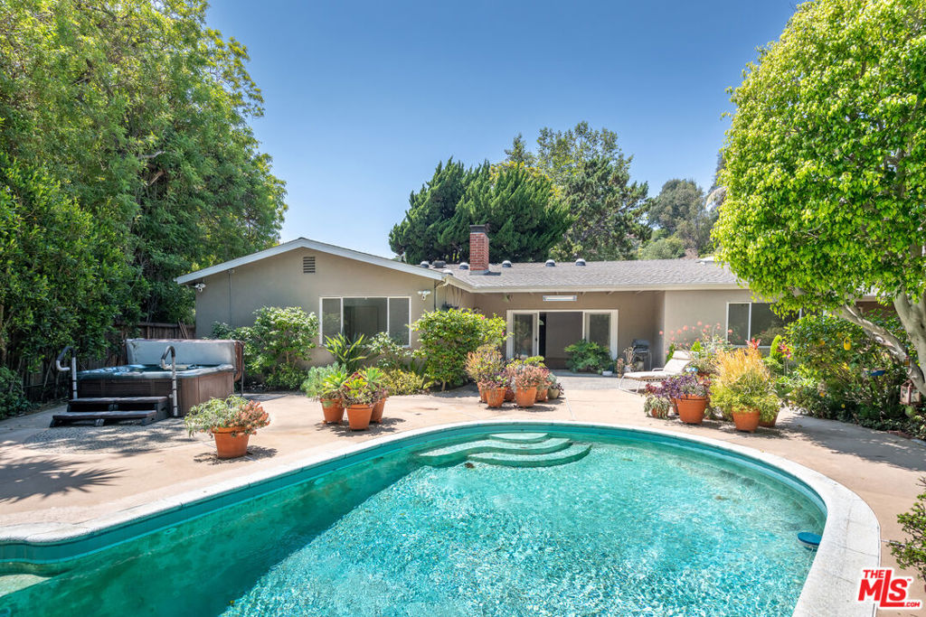 Classic California Ranch in One of Brentwood's Most Coveted Neighborhoods. Tucked away on a quiet, tree-lined street in one of Brentwood's most prestigious enclaves, this well-maintained 5-bedroom, 3-bathroom single-story California Ranch-style home offers timeless appeal, gracious living, and endless potential. Just moments from the Riviera Country Club, Polo Fields, and the iconic Brentwood Country Mart, the home sits on an oversized 9,602 sq ft lot, ideal for a custom renovation or new construction. Step inside to a grand living space that seamlessly blends a formal living room, a cozy family area, and a generous dining spaceall opening to a private, sun-filled backyard with a pool, perfect for both entertaining and everyday relaxation. Down the hallway, three spacious guest bedrooms share a full bath, while the primary suite offers garden views and an expansive en-suite bathroom. The well-sized kitchen includes stainless steel appliances, ample cabinetry, and a sunny breakfast nook. A separate laundry room leads to a fifth bedroom and third bathperfect for guests, staff, or a home office. Located just minutes from Brentwood Country Club and a short stroll to Paul Revere Middle School, this home is situated in a true neighborhood setting, complete with sidewalks, wide streets, and underground utilities - Trust Sale.