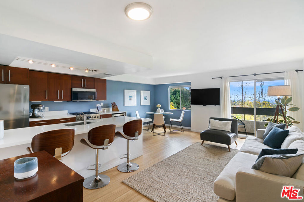 Welcome to Cahuenga Hills Tennis Condominiums, a 15 acre resort style complex with guard gated entry and offering an impressive array of amenities. Nestled into Cahuenga Pass, this unit is in building 3, which is the deepest back into the hills and furthest away from the freeway. A bright unit, with bamboo flooring and tons of natural light. The kitchen features a brand new stainless steel Bosch 800 Series, industrial grade gas range with 5 burners, Frigidaire Pro over-the-range microwave / convection oven combo and a stainless steel wine cooler. Kitchen counters are white quartz and with bar-top seating, allow one to move freely from the living room to the kitchen while enjoying the view across the Hills towards the South Bay. Before the bedroom, and off the entry, is your in-unit laundry area featuring a new Bosch 300 series stackable front load washer/ dryer. The home has a keyless smart entry pad and an Alexa enabled smart thermostat that controls the central HVAC. The bedroom is generously sized with space for a desk/work space and features a walk-in closet. Off of the living room the balcony has space for bistro table and chairs to enjoy morning coffee or warm evenings. A rare and special feature is that from outside your building there is access the private Terracotta trail leading out of the community and up to the ridge with a spectacular view over Lake Hollywood and the entire city. This invites an active lifestyle, as the community also offers two pools, Jacuzzi, three tennis courts, and a modern/updated gym with top tier equipment. The community clubhouse has two billiard tables and a brand new ping pong table, kitchen and lounge area. In addition to the main pool, right behind our building is a secondary and more secluded one. Be in the heart of town next to LA's top attractions including Runyon Canyon, Franklin Village, and the The Hollywood Bowl with convenient access to the freeways and to the Valley. Rent includes water, waste disposal and Spectrum WiFi. There is also additional private storage above your assigned covered parking space.