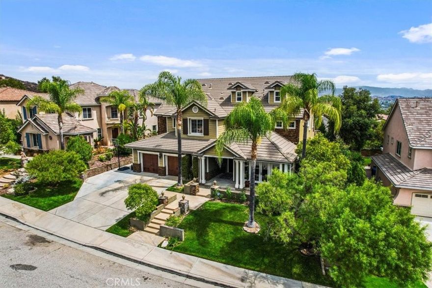 This magnificent home, located in Valencia’s prestigious Tesoro del Valle community, is a true showcase of luxury and craftsmanship. Built in 2004, this expansive single-family residence offers approximately 5,023 square feet of living space on a generous 8,462 sq ft lot, featuring 6 bedrooms and 6 bathrooms. Step inside to discover an atmosphere of elegance, highlighted by soaring ceilings, refined crown molding, and rich hardwood flooring that create a warm and inviting ambiance. The formal living room, accented by French doors that open to the front patio, flows seamlessly into a grand dining area—perfect for entertaining. At the heart of the home lies a gourmet kitchen, equipped with a custom tile backsplash, stainless steel appliances, a Sub-Zero refrigerator, Thermador microwave, GE Monogram stove, GE Profile double ovens, and a wine cooler. The kitchen opens to a bright breakfast nook and cozy den overlooking the backyard oasis. A convenient first-floor en-suite bedroom provides comfort and privacy for guests, complemented by a nearby powder room. Upstairs, four additional bedrooms include a luxurious primary suite with its own balcony offering scenic views, a spacious walk-in closet, dual vanities, solid marble slab shower walls, and a soaking tub. Two bedrooms share a Jack-and-Jill bathroom, while another features its own private bath. On the third level, a private suite includes a full bath and walk-in closet—ideal as a sixth bedroom, home office, theater, or playroom, offering exceptional versatility. The backyard retreat is designed for both relaxation and entertaining, featuring a sparkling pool, lush landscaping, and serene views. Additional highlights include a spacious 4-car garage, owned Tesla solar system, Tesla charger, whole-house water filtration and softener, and a gas-powered generator. Residents of Tesoro del Valle enjoy access to premium amenities, including a clubhouse, community pool, lake, sports fields, playgrounds, and more.