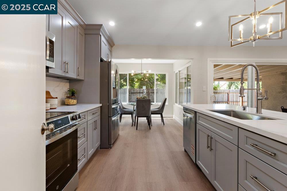 Welcome to this completely renovated 4-bedroom, 2-bathroom home offering 1,678 sq. ft. of beautifully updated living space—all on a generous lot! Step inside and be welcomed by soaring ceilings and an abundance of natural light that fills every room. Gorgeous hardwood flooring flows throughout, setting the tone for a sleek and modern aesthetic. The heart of the home is the chef-inspired kitchen, featuring contemporary grey cabinetry, elegant countertops, and a full suite of brand-new stainless steel appliances. Whether you're entertaining or enjoying a quiet breakfast, the bright and airy breakfast nook overlooks the spacious backyard—perfect for indoor-outdoor living. Conveniently located near schools, scenic parks, shopping, and with easy freeway access, this home truly combines style, comfort, and functionality. Move-in ready and waiting for you to call it home!