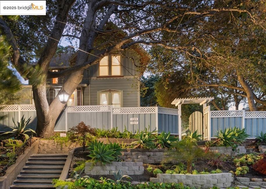Situated upon a beautifully landscaped one-third-acre promontory, 1924 7th Avenue is a unique opportunity to own a legacy estate unlike any other in Oakland. Gated and set above the street, this extraordinary property offers a rare sense of privacy, history, and artistic inspiration. Originally owned by renowned California artist Raymond Dabb Yelland—whose luminous paintings of Lake Merritt and the Bay were exhibited in major museums—the estate served as both his home and creative sanctuary. Yelland built his atelier on the grounds, and the main Victorian residence still bears his signature as if it were one of his canvases. Today, the property encompasses three distinct residences, each with its own tranquil garden setting. The primary home is a gracious three-bedroom Victorian plus office, offering views across the estate’s layered landscaping. Below it, a modern one-bedroom garden apartment provides a stylish and self-contained living space. At the rear of the property, the charming cottage apartment includes one bedroom plus an office, ideal for guests, extended family, or creative use. A rare offering that blends architectural heritage, artistic provenance, and multi-residential flexibility—all just moments from Lake Merritt, the city center, BART and the best of Oakland.