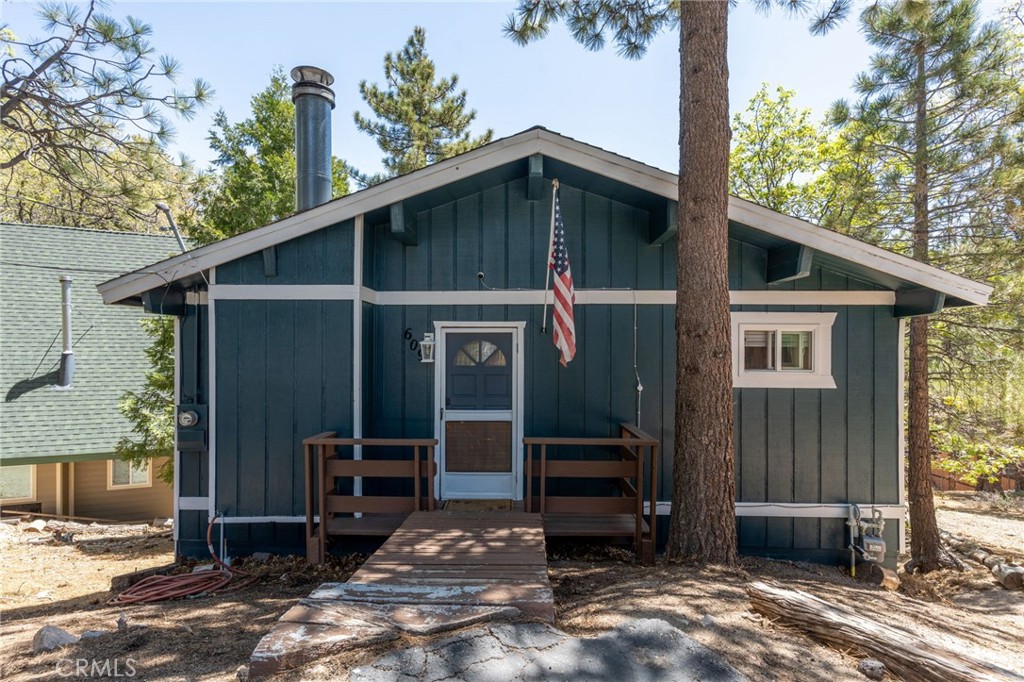Welcome to your peaceful escape in the heart of Green Valley Lake! This beautifully updated 2-bedroom, 2-bathroom home offers 1,074 square feet of thoughtfully designed living space. With great curb appeal and features, this home is one you don’t want to miss. Situated with two parking spaces at the front, you will enter this home as you head toward the entryway with a small porch. As you step inside you will be greeted with a main-level open concept that flows seamlessly with a vaulted ceiling, wood paneling, LVP flooring, and tons of natural light from the surrounding windows. Within the main level, you have your living room area with a stone fireplace, a full bathroom in the corner, and your updated kitchen with ample storage and a convenient washer and dryer setup for everyday ease. From the main level, you can step outside to the expansive deck that is perfect for entertaining or enjoying the peaceful surroundings and views. Heading back inside, you can find your two bedrooms with a Jack & Jill bathroom, all within the lower level of the home. The bedrooms are of good size and each have their own closet. From the lower level, there is also another door that allows you to enter the backyard. This area is located under the deck and makes the perfect storage space for all your outdoor necessities. Some other notable features within include: dual pane windows with new blinds and newer interior & exterior paint. Whether you’re looking for a full-time residence or a weekend getaway with the ability to offer it as a short-term rental, this home has everything you need to enjoy the Green Valley Lake Community. Within the community, residents enjoy seasonal fishing, kayaking, and swimming in the designated beach area through summer; along with hiking, off-roading trails, and access to nearby ski resorts in winter. Whether you're looking for a weekend getaway or a full-time mountain home, this property offers the perfect blend of comfort, tranquility, and outdoor adventure. Come experience the beauty of Green Valley Lake and take the opportunity to call this home your own!