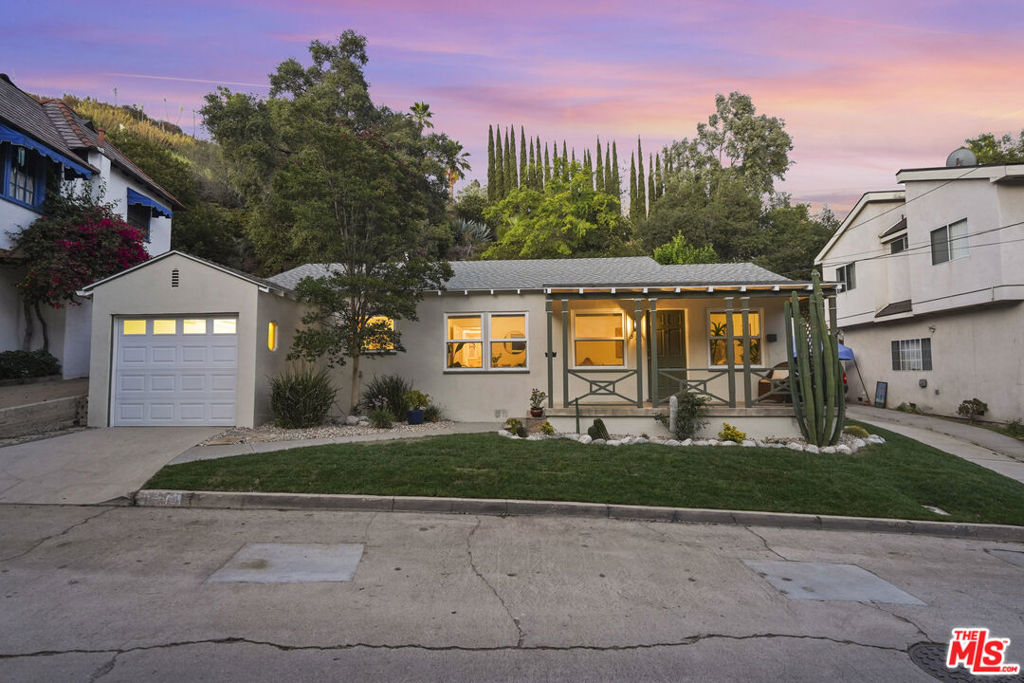 Charming, light-filled, and full of character, this traditional home on Sinclair Avenue offers incredible value in one of Glendale's most convenient pockets. Set just off Chevy Chase, this two-bedroom home is ideal for a first-time buyer or anyone looking for a thoughtfully maintained property with a private outdoor setting. A grassy lawn and a front porch with vintage charm create an inviting first impression. The home's classic silhouette and tidy curb appeal create a warm welcome. Inside, rich hardwood floors and freshly painted interiors set the tone for a warm, comfortable space. The living room features original built-ins and abundant natural light, flowing directly into the dining area and through to a kitchen that is both efficient and highly functional. Both bedrooms are nicely sized and share a central hallway that adds a sense of separation from the entertaining spaces. The backyard is a quiet surprise, tucked into the hillside and designed with multiple outdoor areas for entertaining or relaxing. A covered patio with skylights offers a shady retreat just off the home, while a short staircase leads to a second, secluded seating area surrounded by greenery and mature native plants. It's peaceful, private, and unexpectedly spacious. Additional features include central air, a one-car garage, and an unbeatable location near parks, shopping, and neighborhood favorites. With its smart layout, hillside privacy, and undeniable curb appeal, this home is a rare opportunity to get into a desirable Glendale neighborhood at a great value.